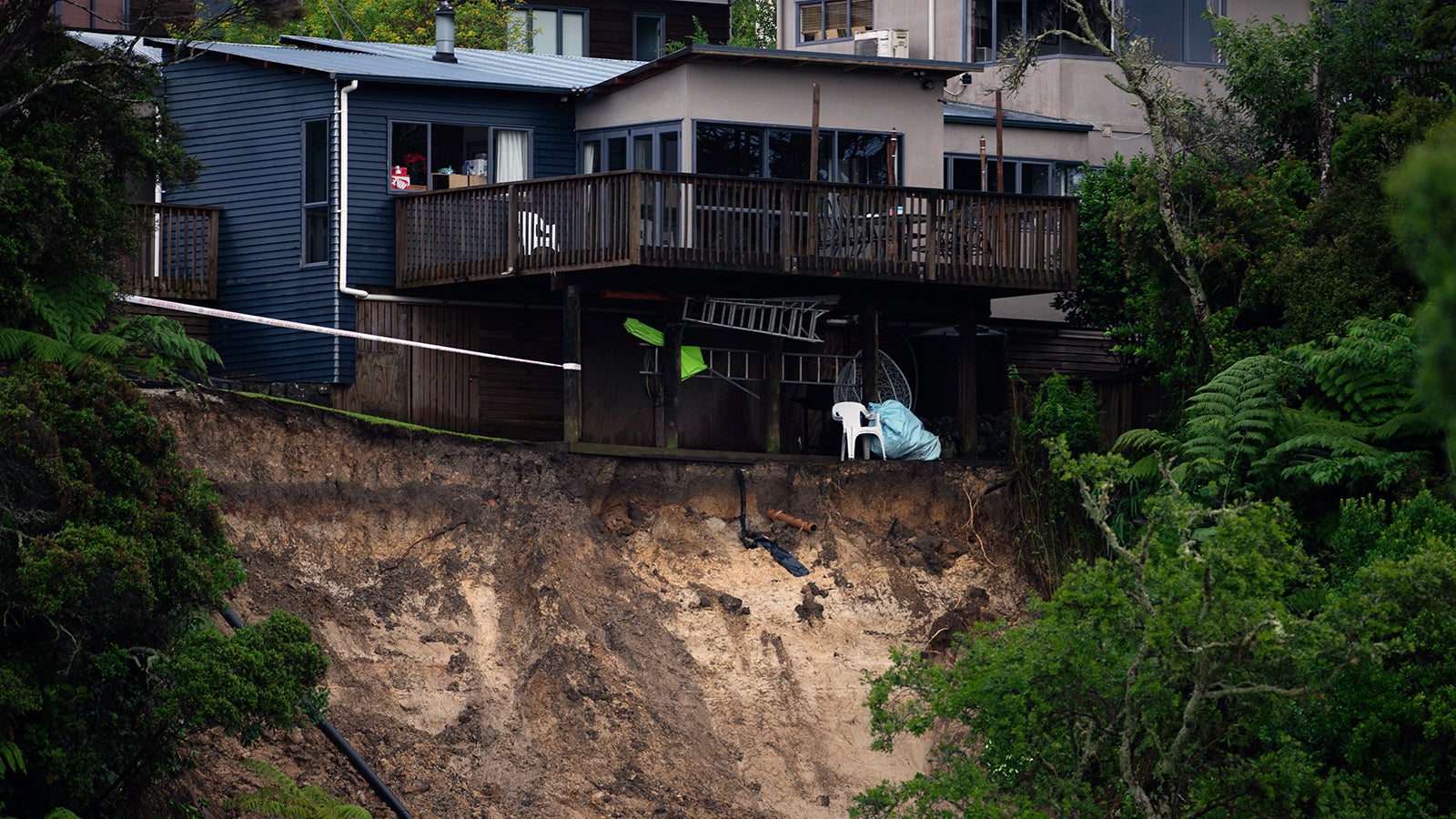 A landslip caused by flood water undermines a house in Auckland, Saturday, Jan. 28, 2023. Record levels of rainfall pounded New Zealand's largest city, causing widespread disruption.  (Hadyen Woodward/New Zealand Herald via AP)