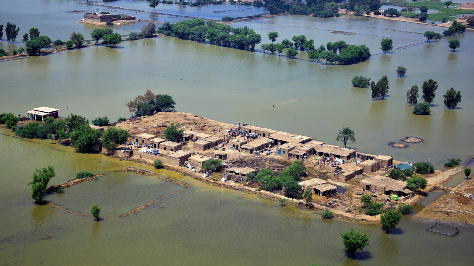 Homes are surrounded by floodwaters in Jaffarabad, a district of Pakistan's southwestern Baluchistan province, Saturday, Sep. 3, 2022. The homeless people affected by monsoon rains triggered devastating floods in Pakistan get enhancing international attention amid growing numbers of fatalities and homeless families across the country as the federal planning minister appealed the international community for immense humanitarian response for 33 million people. (AP Photo/Arshad Butt)