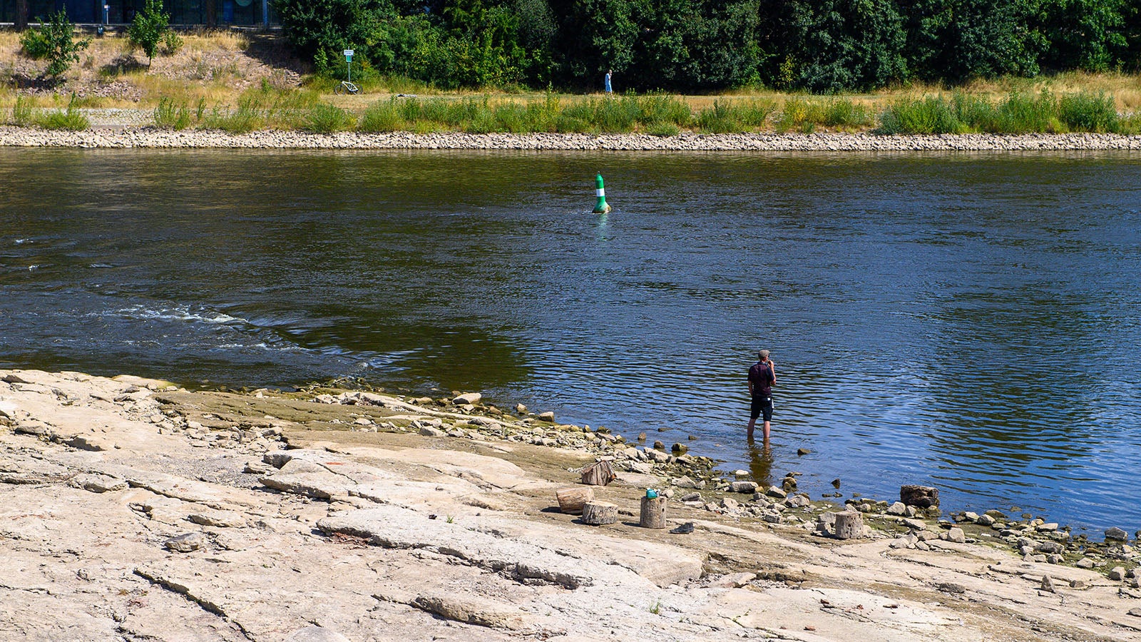 10.07.2025, Sachsen-Anhalt, Magdeburg: Ein Mann steht am Domfelsen im Wasser der Elbe und k&uuml;hlt sich die F&uuml;&szlig;e. An der Elbe ist voraussichtlich ein historisches Niedrigwasser gemessen worden. Wie die Bundesanstalt f&uuml;r Gew&auml;sserkunde mitteilte, fiel der Wasserstand am Pegel der Strombr&uuml;cke auf 44 Zentimeter. Der bisherige Tiefststand liegt nach Angaben des Wasserstra&szlig;en- und Schifffahrtsamt Elbe (WSA) bei 45 Zentimetern aus dem Sommer 2019. Allerdings handele es sich dabei um einen Tagesdurchschnittswert. Die statistisch korrekte Berechnung werde einige Zeit in Anspruch nehmen. Foto: Klaus-Dietmar Gabbert/dpa +++ dpa-Bildfunk +++