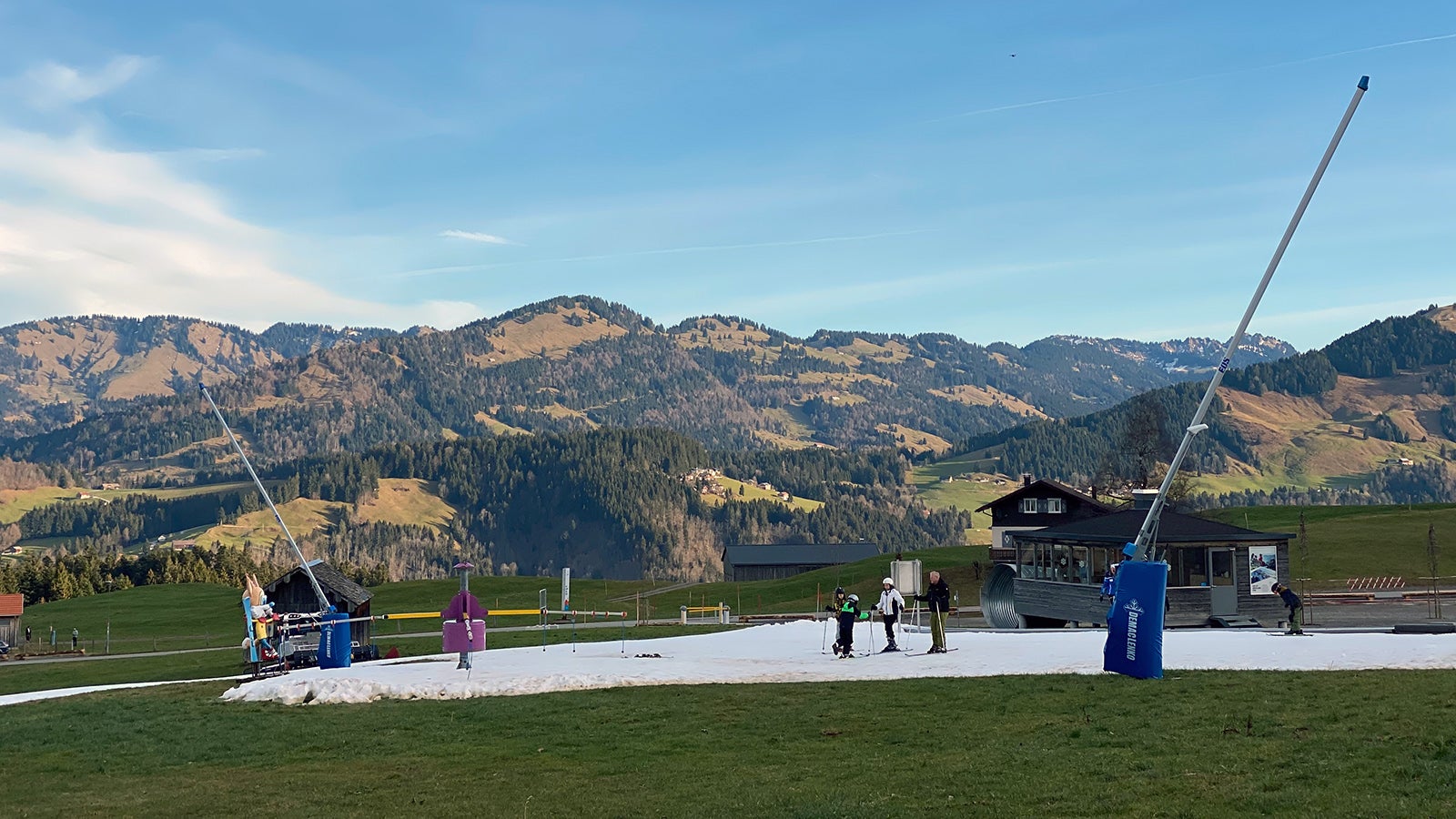 02.01.2023, &Ouml;sterreich, Schetteregg: Auf einem Flecken, der k&uuml;nstlich mit Schnee pr&auml;pariert wurde, &uuml;ben Anf&auml;nger im Skigebiet Schetteregg die ersten Schritte auf Skiern. F&uuml;r die Jahreszeit ist es hier derzeit viel zu warm. Foto: Benedikt von Imhoff/dpa - ACHTUNG: Verwendung nur im vollen Format +++ dpa-Bildfunk +++
