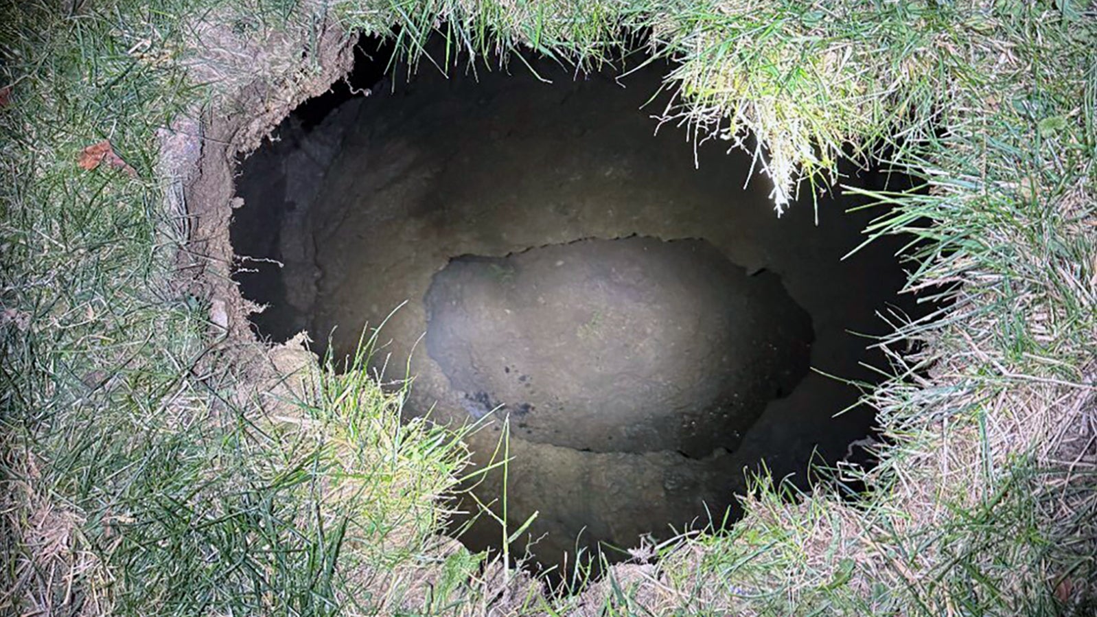 Rettungskr&auml;fte vermuten, dass die vermisste 64-j&auml;hrige Gro&szlig;mutter aus Pennsylvania in dieses 9 Meter tiefe Erdloch gefallen ist. (Pennsylvania State Police via AP)