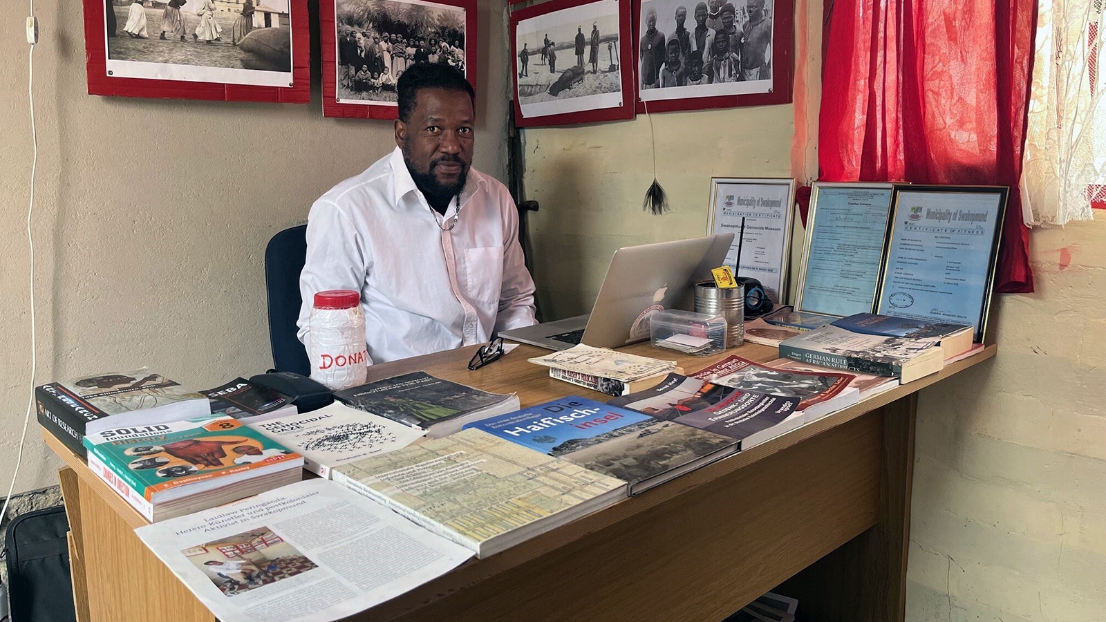 ARCHIV - 04.08.2024, Namibia, Swakopmund: Der Aktivist Laidlaw Peringanda (49) sitzt am Schreibtisch seines Genozid Museums in der namibischen K&uuml;stenstadt Swakopmund. Er will &uuml;ber den V&ouml;lkermord aufkl&auml;ren, der 1904-1908 w&auml;hrend der Kolonialzeit von deutschen Truppen in Namibia ver&uuml;bt wurde. (zu dpa: &laquo;Die wohl deutscheste Stadt au&szlig;erhalb Deutschlands&raquo;) Foto: Kristin Palitza/dpa +++ dpa-Bildfunk +++