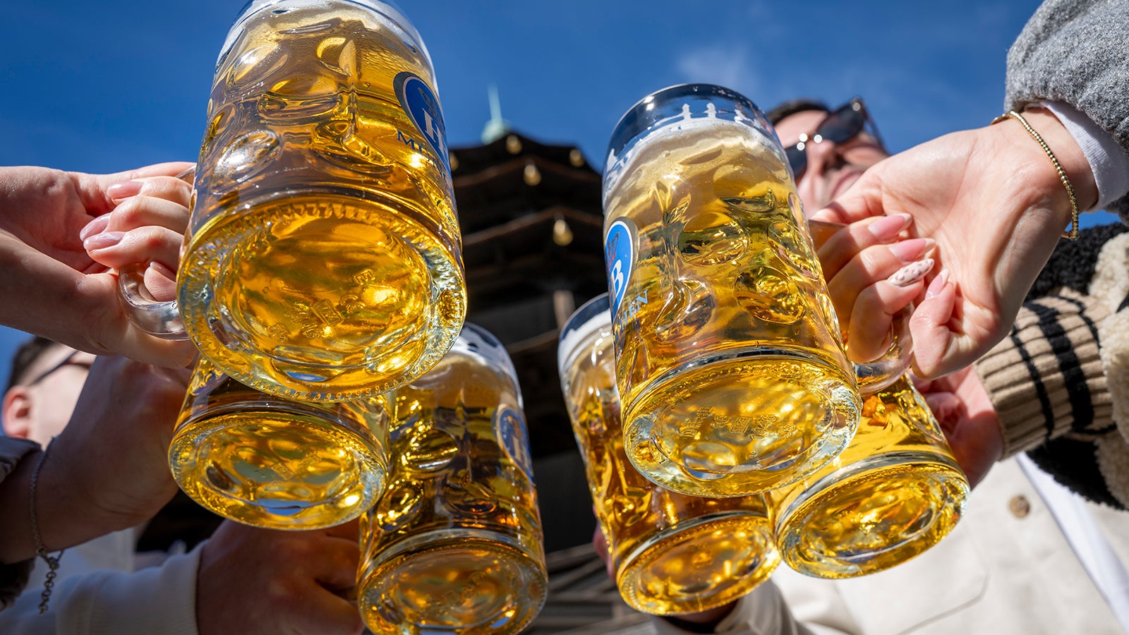Touristen sto&szlig;en bei fr&uuml;hlingshaftem Wetter mit Bierkr&uuml;gen am Chinesischen Turm an. Der Turm mit seinem Biergarten gilt als Wahrzeichen der bayerischen Landeshauptstadt und liegt im Englischen Garten. Foto: Peter Kneffel/dpa +++ dpa-Bildfunk +++