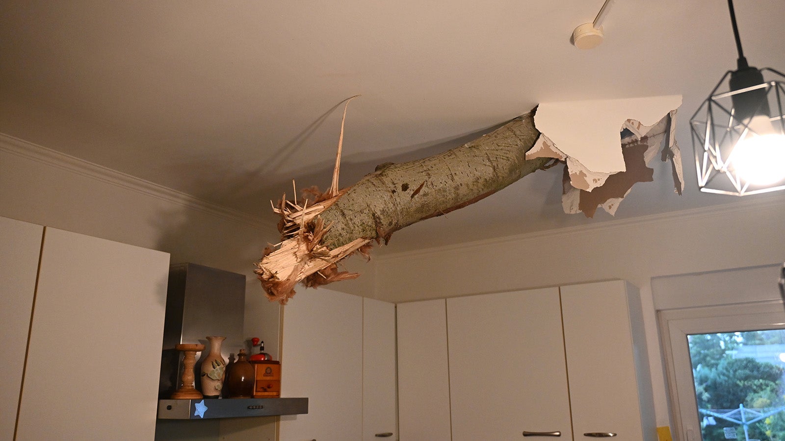 Ein Baumstamm ragt nach einem Unwetter in F&uuml;rstenwalde-S&uuml;d aus der Decke in der K&uuml;che eines Wohnhauses. Bei einem Unwetter sind mehrere B&auml;ume umgest&uuml;rzt und Autos besch&auml;digt worden. Foto: dpa