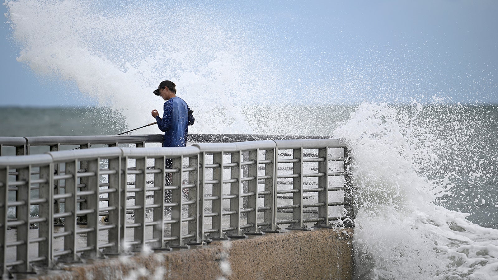 Nathan Goff gets drenched by a crashing wave, while fishing on the jetty at Sebastian Inlet State Park, as Tropical Storm Imelda passes offshore, Monday, Sept. 29, 2025, in Melbourne Beach, Fla. (AP Photo/Phelan M. Ebenhack)