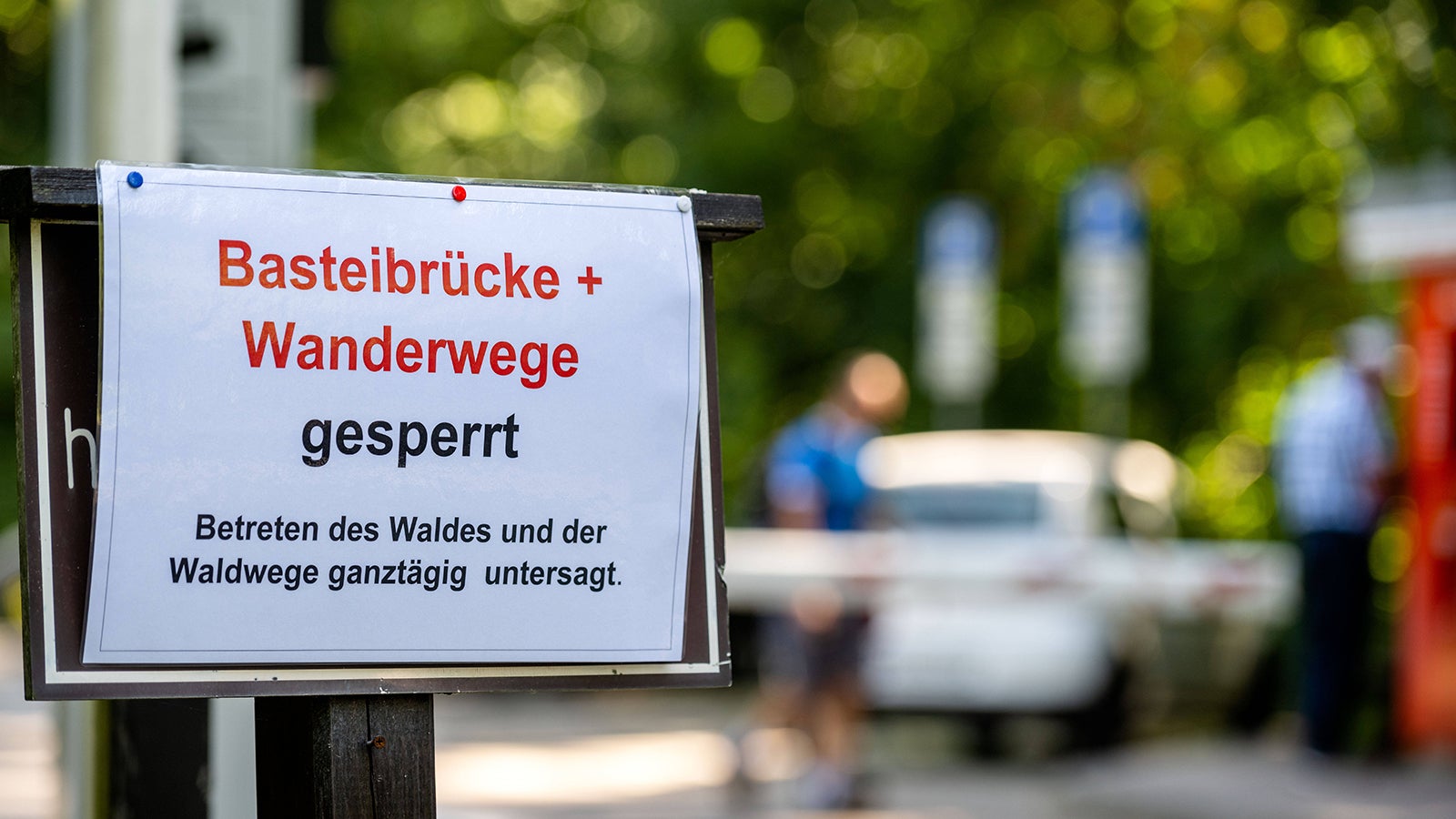 28.07.2022, Deutschland, Sachsen, S&auml;chsische Schweiz, Lohmen: Schilder verweisen auf die gesperrte Basteibr&uuml;cke bei Lohmen in der S&auml;chsischen Schweiz. Aufgrund der massiven Waldbr&auml;nde im Naturschutzgebiet S&auml;chsische Schweiz ist das Betreten der Br&uuml;cke ebenso untersagt wie das Betreten der Wander- und Waldwege. Im tschechischen und deutschen Teil des Nationalparks brennen seit Tagen hunderte Hektar Nadelwald. *** 28 07 2022, Germany, Saxony, Saxon Switzerland, Lohmen Signs point to the closed Bastei Bridge near Lohmen in Saxon Switzerland Due to the massive forest fires in the Saxon Switzerland nature reserve, it is forbidden to enter the bridge as well as the hiking and forest trails In the Czech and German parts of the national park, hund