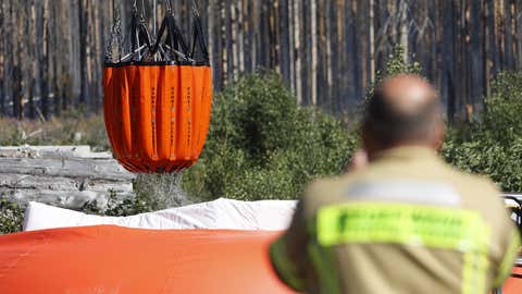 12.08.2022, Sachsen-Anhalt, Schierke: Einsatzkräfte der Feuerwehr überwachen im Einsatzgebiet die Wasserversorgung für die Hubschrauberlöscharbeiten. Seit Donnerstag brennt eine größere Waldfläche im Nationalparkgebiet Harz. Foto: Matthias Bein/dpa +++ dpa-Bildfunk +++