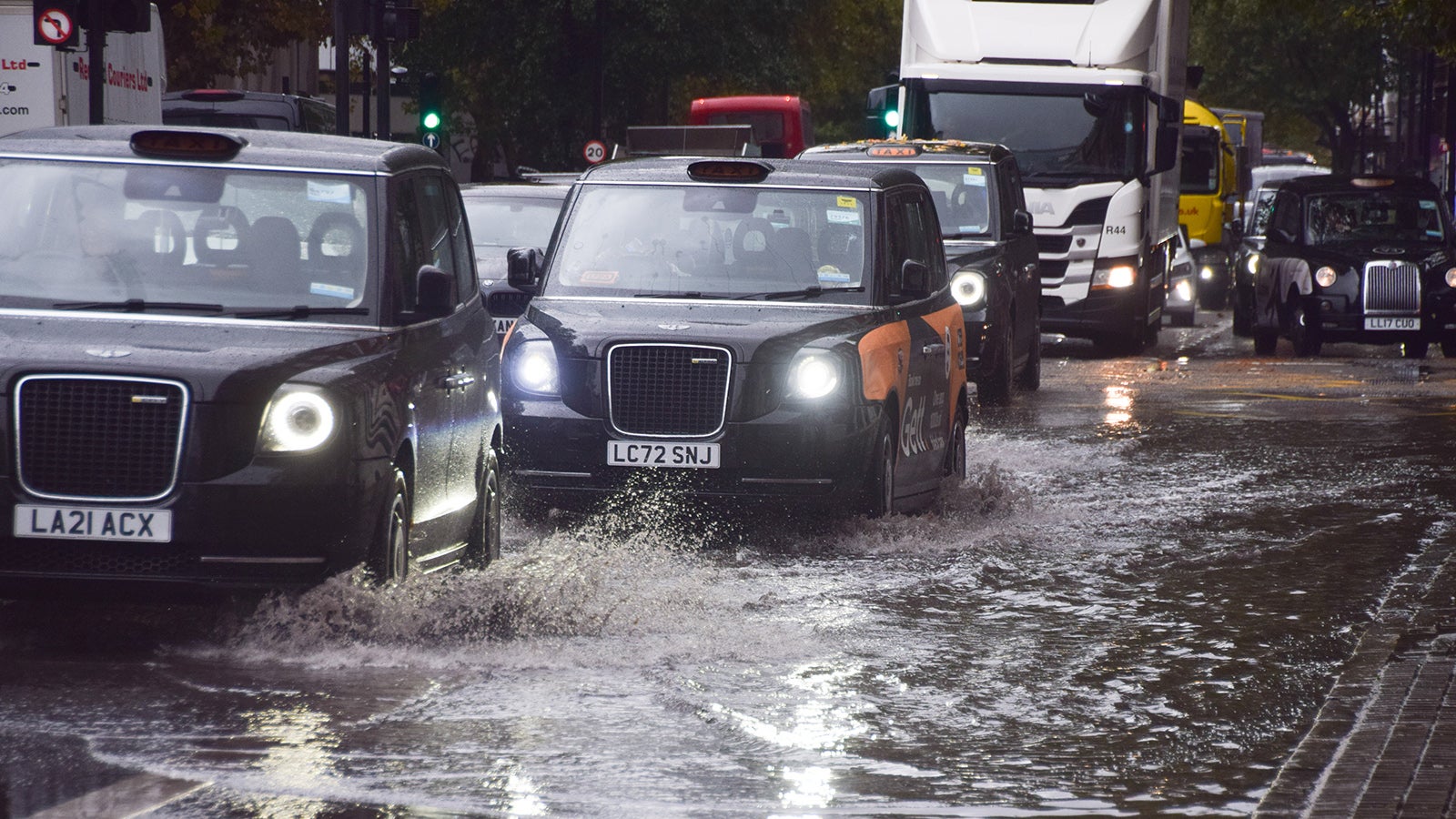 20.10.2025, Gro&szlig;britannien, London: Taxis fahren durch die &uuml;berschwemmte Euston Road, w&auml;hrend starker Regen in der britischen Hauptstadt f&auml;llt. Foto: Vuk Valcic/ZUMA Press Wire/dpa +++ dpa-Bildfunk +++
