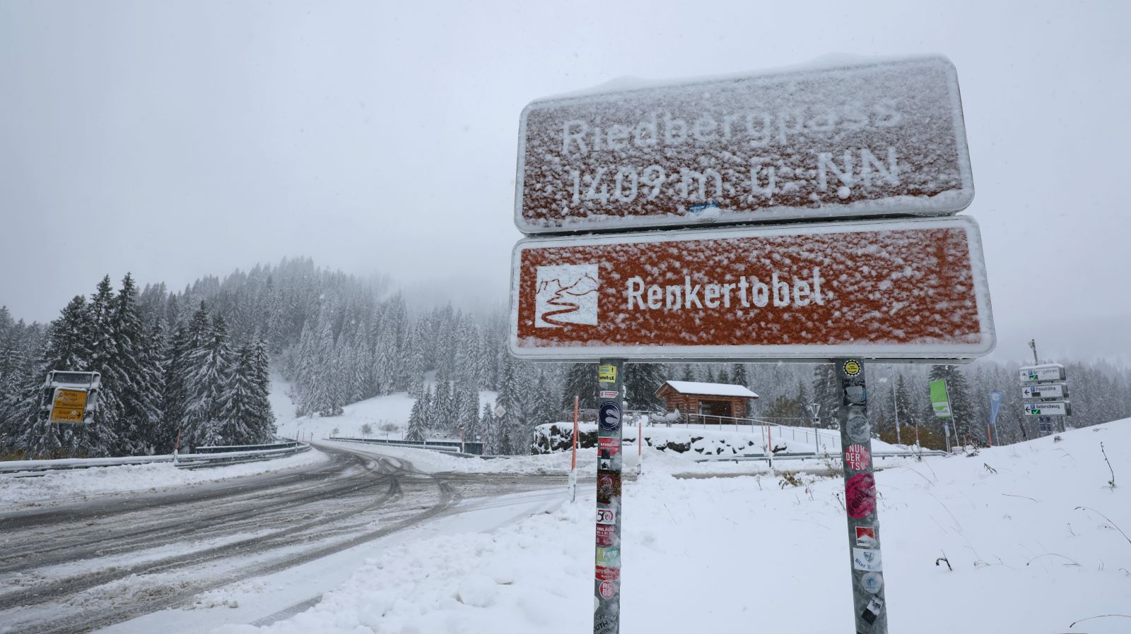 Ein Blick auf das Schild - und die Autofahrer wissen Bescheid. Am Riedbergpass im Allg&auml;u (Bayern) hat es den ersten Neuschnee gegeben. F&uuml;r Fahrzeuge gilt bei diesen Stra&szlig;enverh&auml;ltnissen eine Kettenpflicht, ausgenommen sind nur Pkw mit Allrad-Antrieb. Foto: dpa