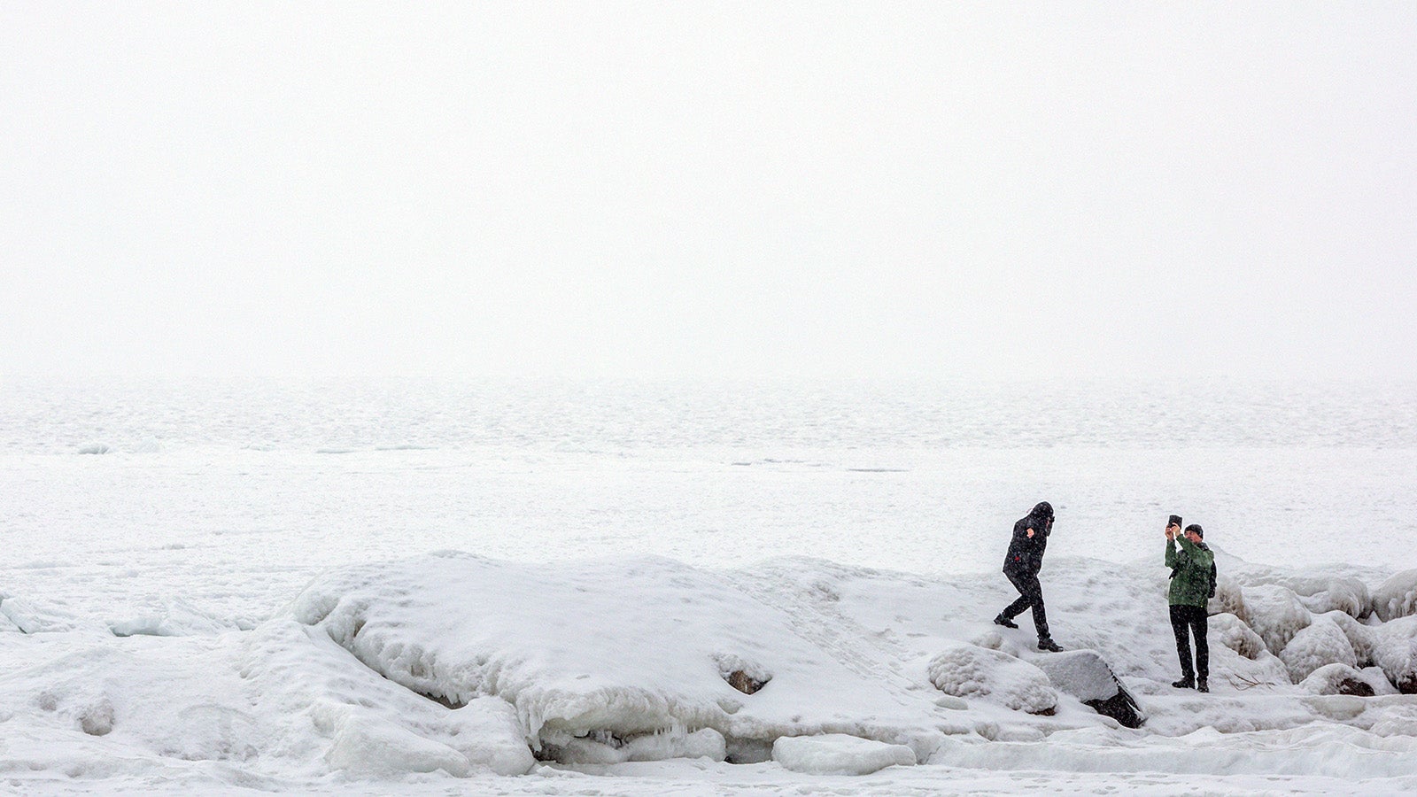 Spazierg&auml;nger sind auf der vereisten Ostsee bei M&ouml;nchgut auf der Ostseeinsel R&uuml;gen unterwegs. Mit Temperaturen um die null Grad und stark bew&ouml;lkt zeigt sich das Winterwetter in Norddeutschland von seiner unfreundlichen Seite. Foto: Jens B&uuml;ttner/dpa