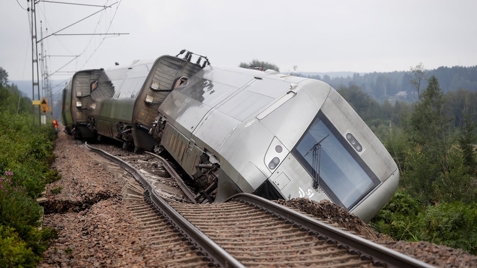dpatopbilder - 07.08.2023, Schweden, Hudiksvall: Ein entgleister Personenzug mit 120 Fahrg&auml;sten liegt neben den Schienen. In der N&auml;he von Hudiksvall rund 300 Kilometer n&ouml;rdlich von Stockholm entgleisten zwei Waggons eines Passagierzuges. Der Bahndamm habe an der Stelle wegen des kr&auml;ftigen Regens nachgegeben, teilte die schwedische Polizei mit. Foto: Mats Andersson/TT News Agency/AP/dpa - ACHTUNG: Nur zur redaktionellen Verwendung und nur mit vollst&auml;ndiger Nennung des vorstehenden Credits +++ dpa-Bildfunk +++