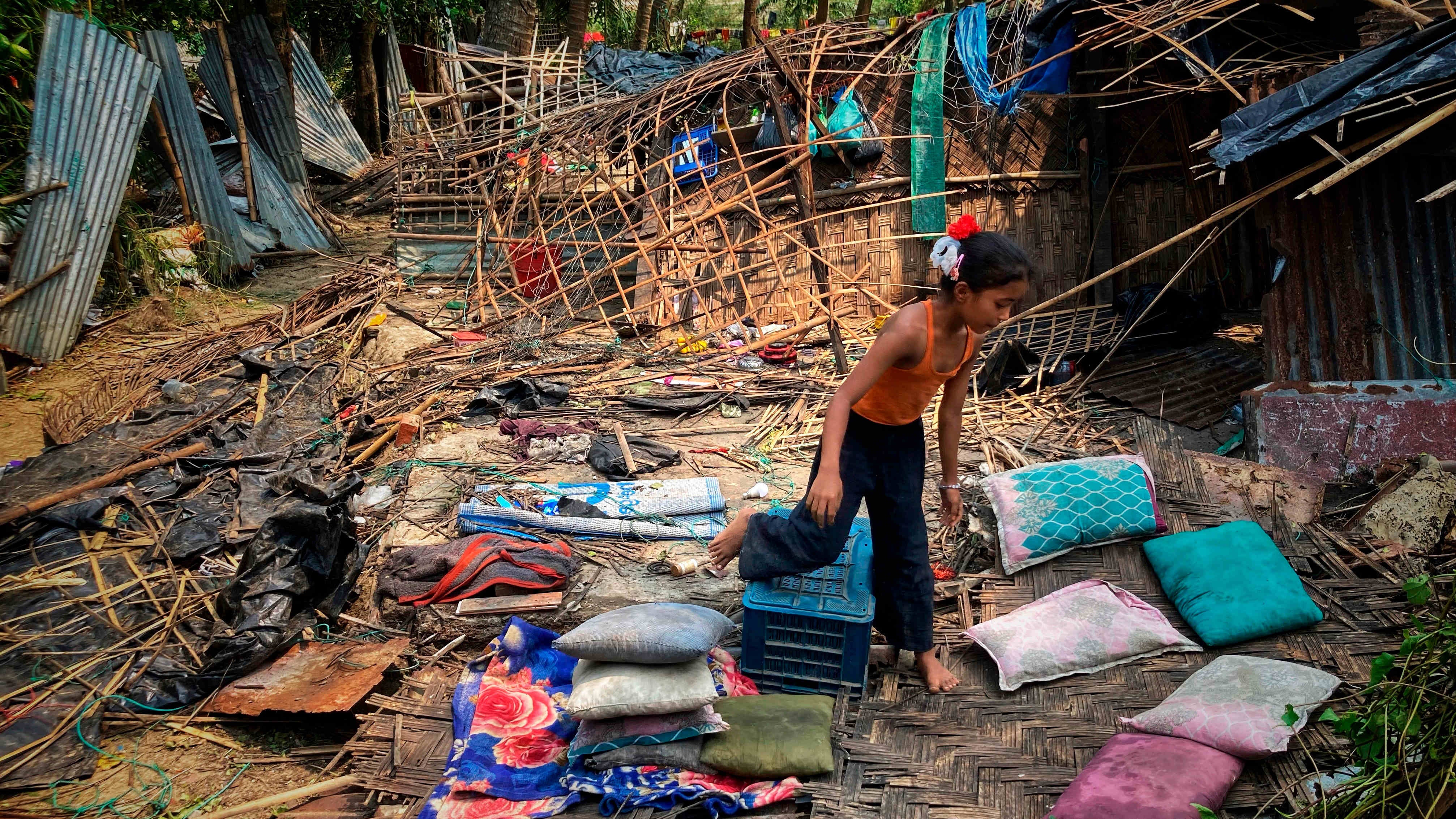 FILE- A child runs through the wreckage of her home damaged by Cyclone Mocha at Saint Martin island in Cox's Bazar, Bangladesh, Monday, May 15, 2023. Early warnings from weather agencies and preparedness by local governments and aid agencies likely saved thousands of lives from a power Cyclone in that might have been claimed by the cyclone that slammed into the joint coastline of Bangladesh and Myanmar on Sunday. But there are concerns over the large number of people still unaccounted for in regions where preventative action was lacking. (AP Photo/Al-emrun Garjon, File)