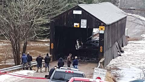 Residents check on the damage to the Bell Bridge in Hoyt, N.B. in this undated handout photo. New Brunswick's stock of historic and picturesque covered bridges continues to decline, with the province acknowledging it cannot save one ravaged by ice and flood waters over the weekend. (Debbie McCann/THE CANADIAN PRESS/HO *MANDATORY CREDIT*)