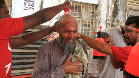 Un grupo de voluntarios refrescan a un anciano en Karachi, en Pakistán, el martes, cuando la temperatura alcanzó los 42 grados. IMRAN ALI / AFP / GETTY