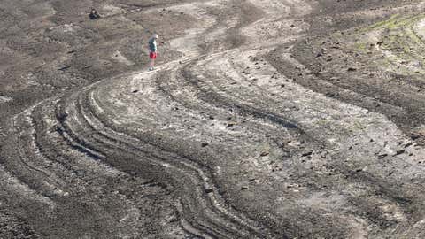 People walk on the dried out bed at Baitings Reservoir as low water levels continue during drought conditions in the heatwave on Aug. 12, 2022 in Ripponden, U.K. (Christopher Furlong/Getty Images)