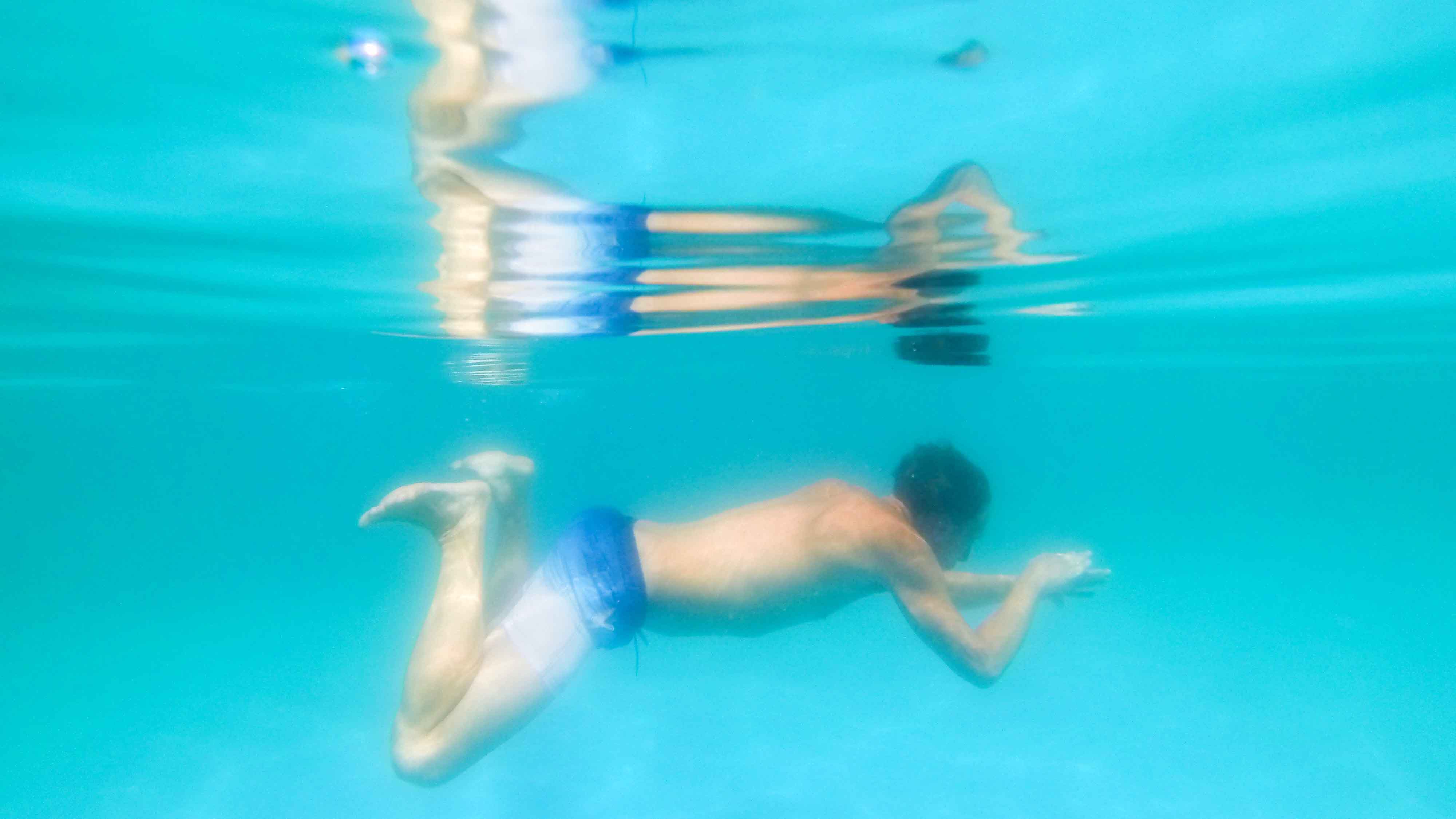 , Niedersachsen, Burgdorf: Philipp schwimmt im Waldbad Ramlingen (Aufnahme mit Unterwasserkamera). Das im Jahr 1939 gebaute Freibad inmitten eines Waldes bei Burgdorf in der Region Hannover kommt seit dem Jahr 2004 dank &ouml;kologischer Filteranlage ganz ohne Chlor aus. (zu dpa "Bio-Schwimmb&auml;der kommen ganz ohne Chlor aus" vom 05.07.2018) Foto: Julian Stratenschulte/dpa +++ dpa-Bildfunk +++ 