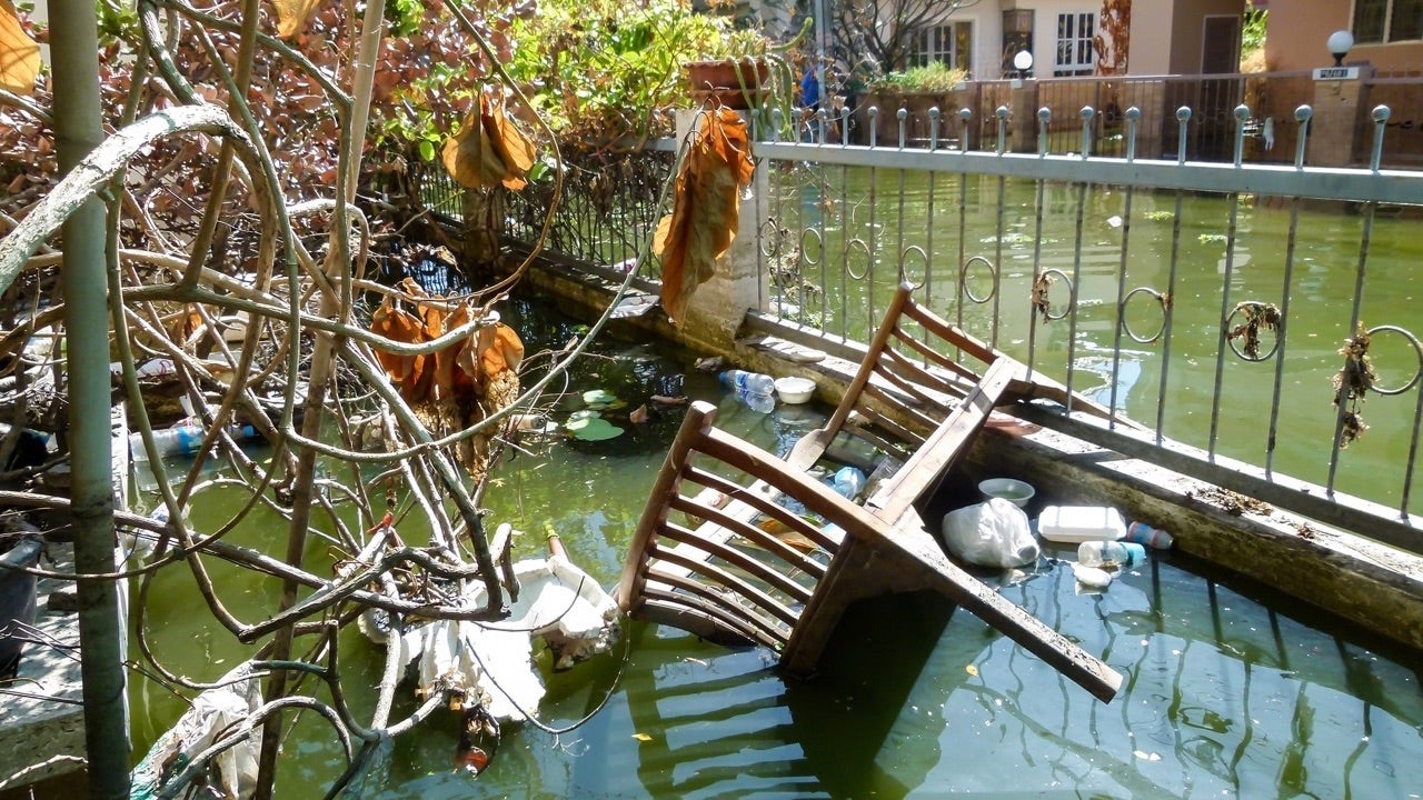 Bangkok,Thailand-Nov 27,2011;Situation after heavy flood for a month.Full of garbage,plastic bottles and wood furniture on the surface of polluted water. (Bangkok,Thailand-Nov 27,2011;Situation after heavy flood for a month.Full of garbage,plastic bot