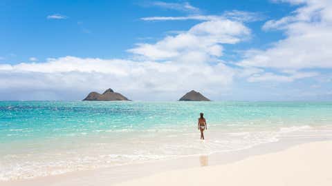 Serene woman in water on vacation at Lanikai beach in Kailua, Oahu, Hawaii.