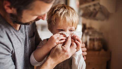 A man with a boy standing at home.