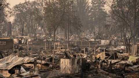 Damaged homes and cars are seen in a mobile home park destroyed by fire on Sept. 10, 2020, in Phoenix, Ore. Hundreds of homes in the town have been lost due to wildfire. (David Ryder/Getty Images)