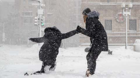 A woman helps her boyfriend stand up after slipping on the sidewalk on December 17, 2020 in Boston, Massachusetts. The Gail winter storm brought more than a foot of snow Wednesday night to the Northeast and Thursday. (Scott Eisen / Getty Images)