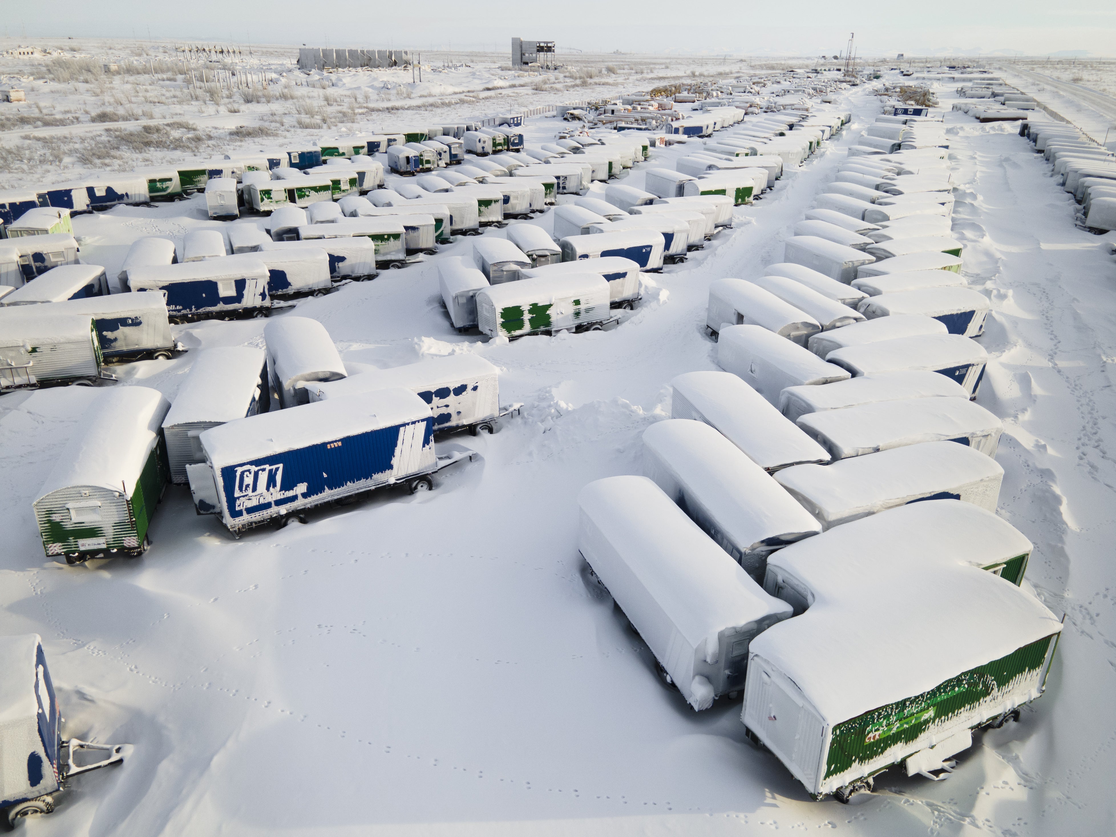 An aerial view shows snow- and ice-covered heavy equipment that have been parked unused for a long time at a construction site in the coal-mining town of Vorkuta, Komi Republic, Russia on March 1, 2021. (Maria Passer/Anadolu Agency via Getty Images)