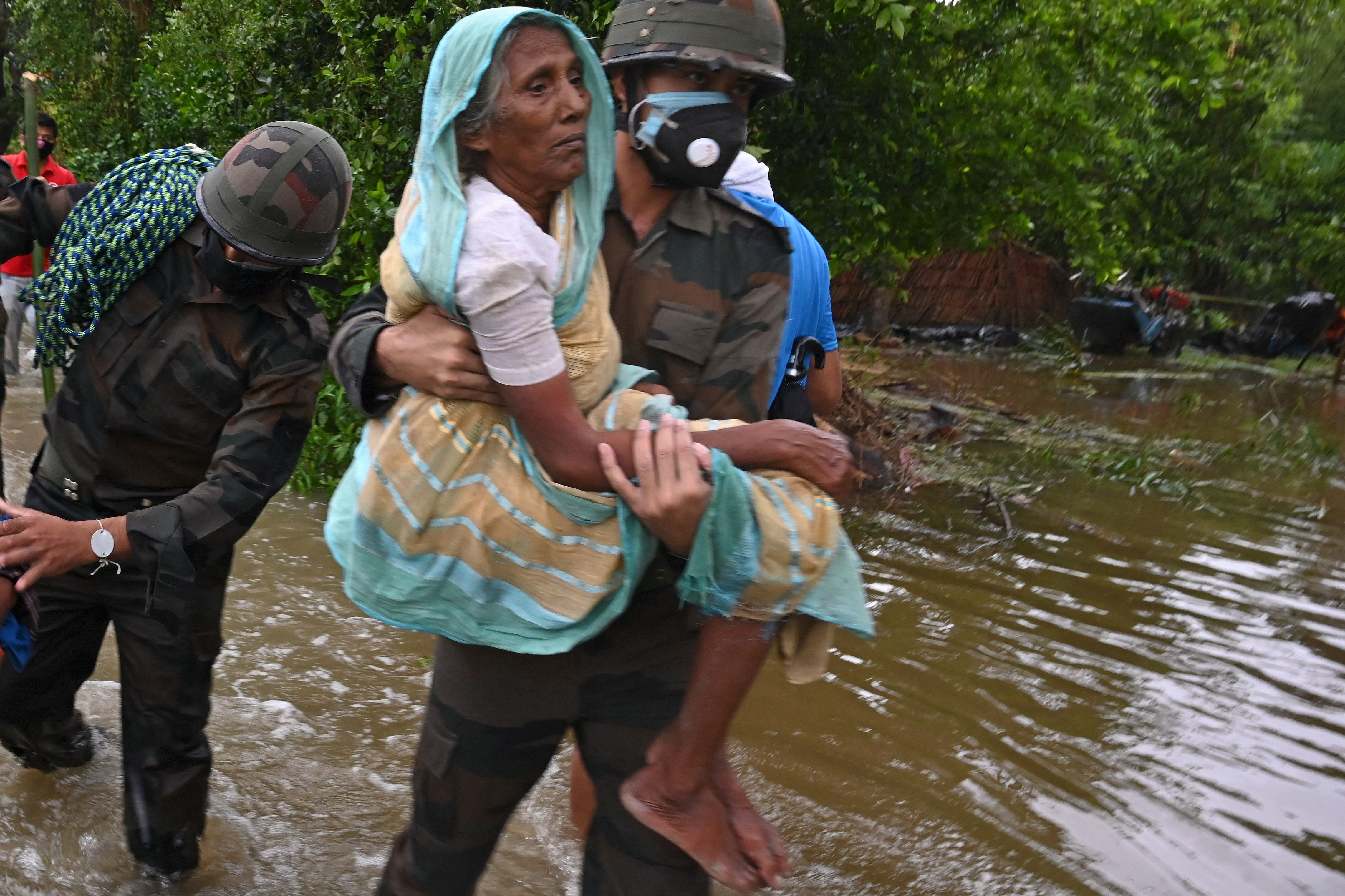 Indian army personnel wade through the flooded village roads carrying people to safety as Cyclone Yaas barrels towards India's eastern coast in the Bay of Bengal, in Ramnagar some 111 miles from Kolkata on May 26, 2021. (Dibyangshu Sakar/AFP via Getty Images)