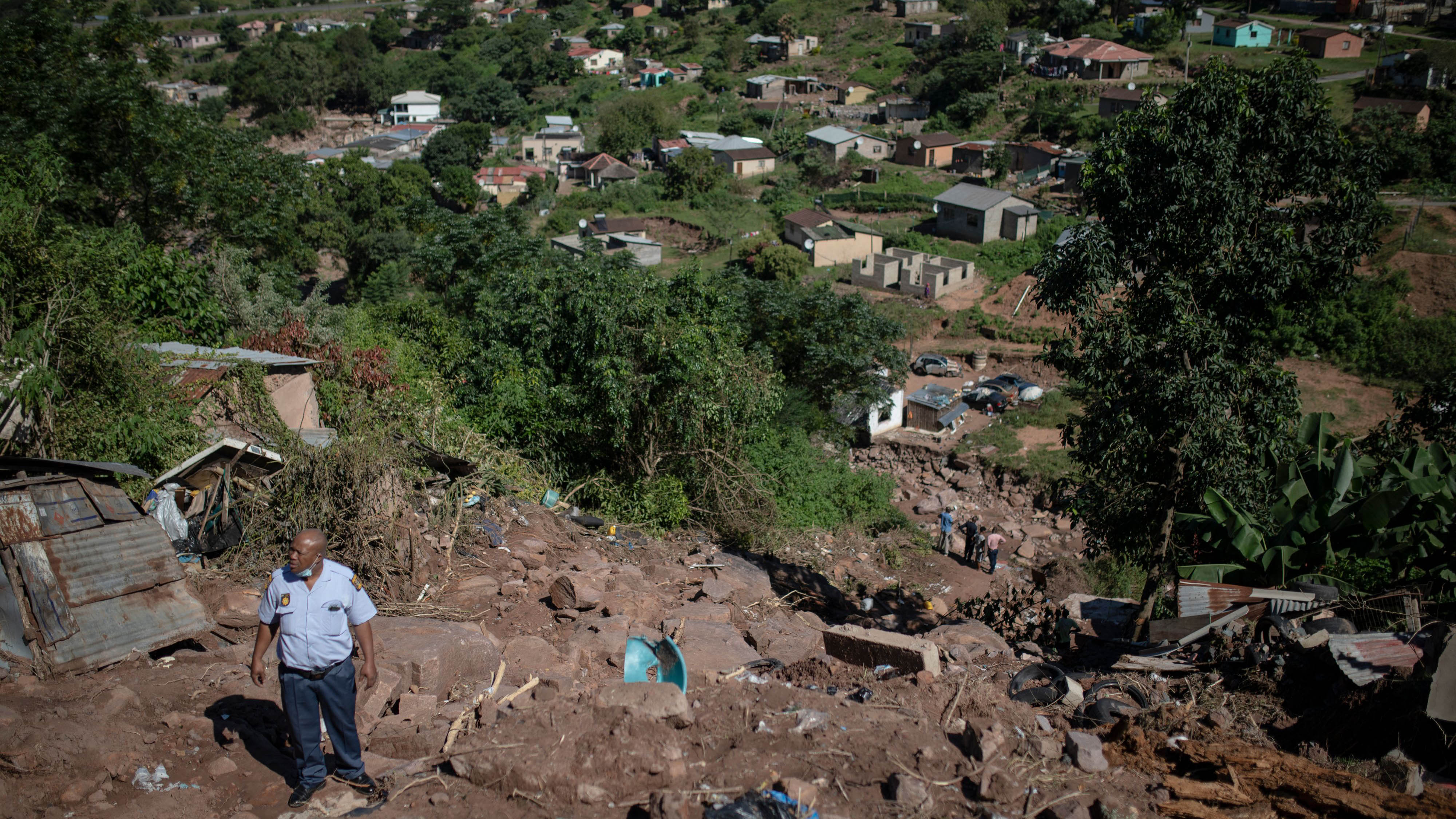 A police officer walks in the area where members of a South African Police Service (SAPS) search and rescue unit (not seen) search for a missing 23 year old man in KwaNdengezi, west of Durban, South Africa, on April 20, 2022. (Guillem Sartorio/AFP via Getty Images)