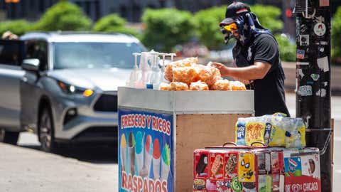 A vendor wearing a wet towel is seen in downtown Chicago on June 14, 2022, as a heat wave hits a large swath of the U.S. (Vincent D. Johnson/Xinhua via Getty Images)