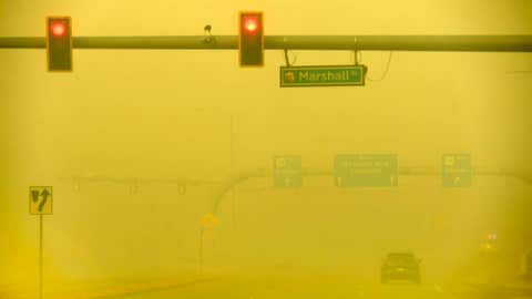 A car makes its way down smoky, yellow skies along McCaslin Blvd on Dec. 30, 2021, in Louisville, Colorado. (Photo by Helen H. Richardson/MediaNews Group/The Denver Post via Getty Images)