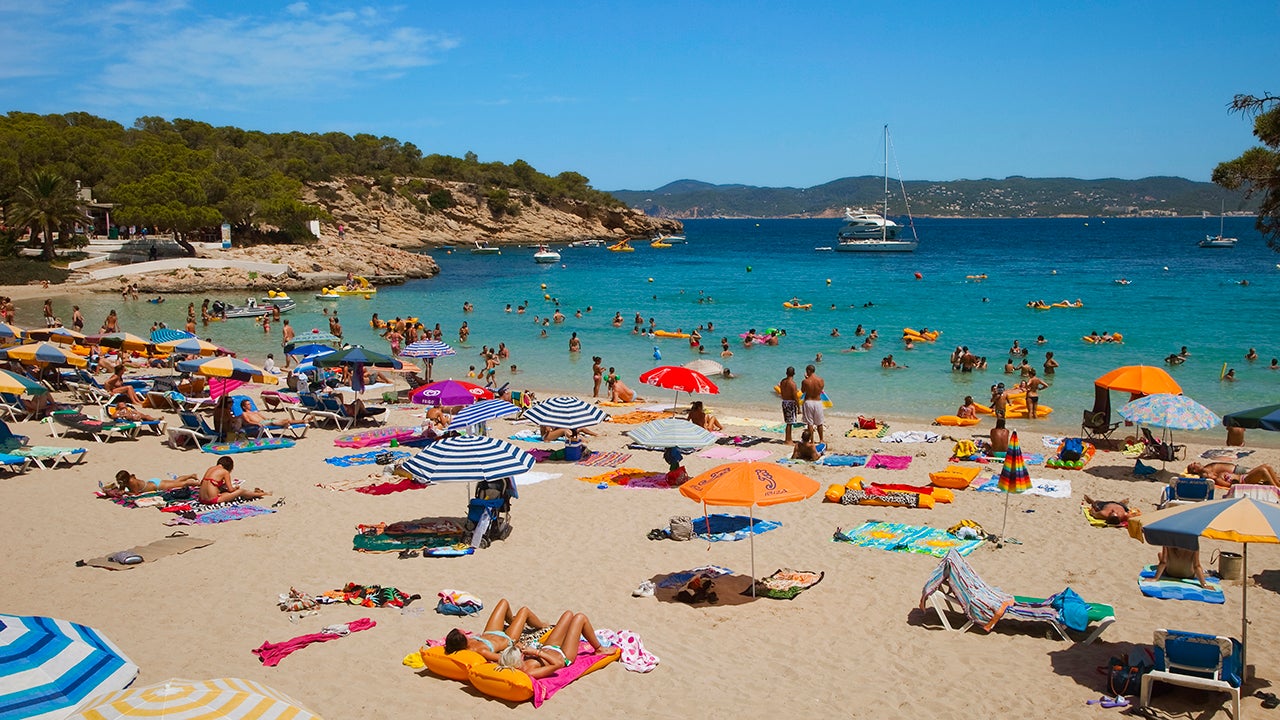 People lounge on Cala Bassa Beach in Ibiza, Spain. (Gonzalo Azumendi via GETTY IMAGES)