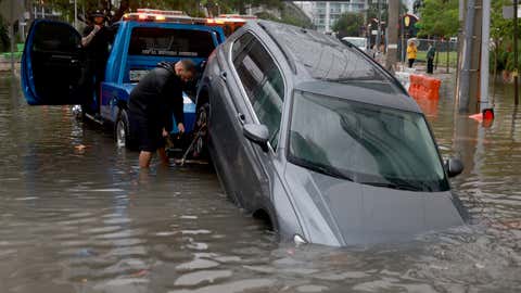 A vehicle is prepared to be towed after it died while being driven through a flooded street caused by a deluge of rain from a tropical disturbance passing through the area on June 4, 2022 in Miami, Florida. (Joe Raedle/Getty Images)