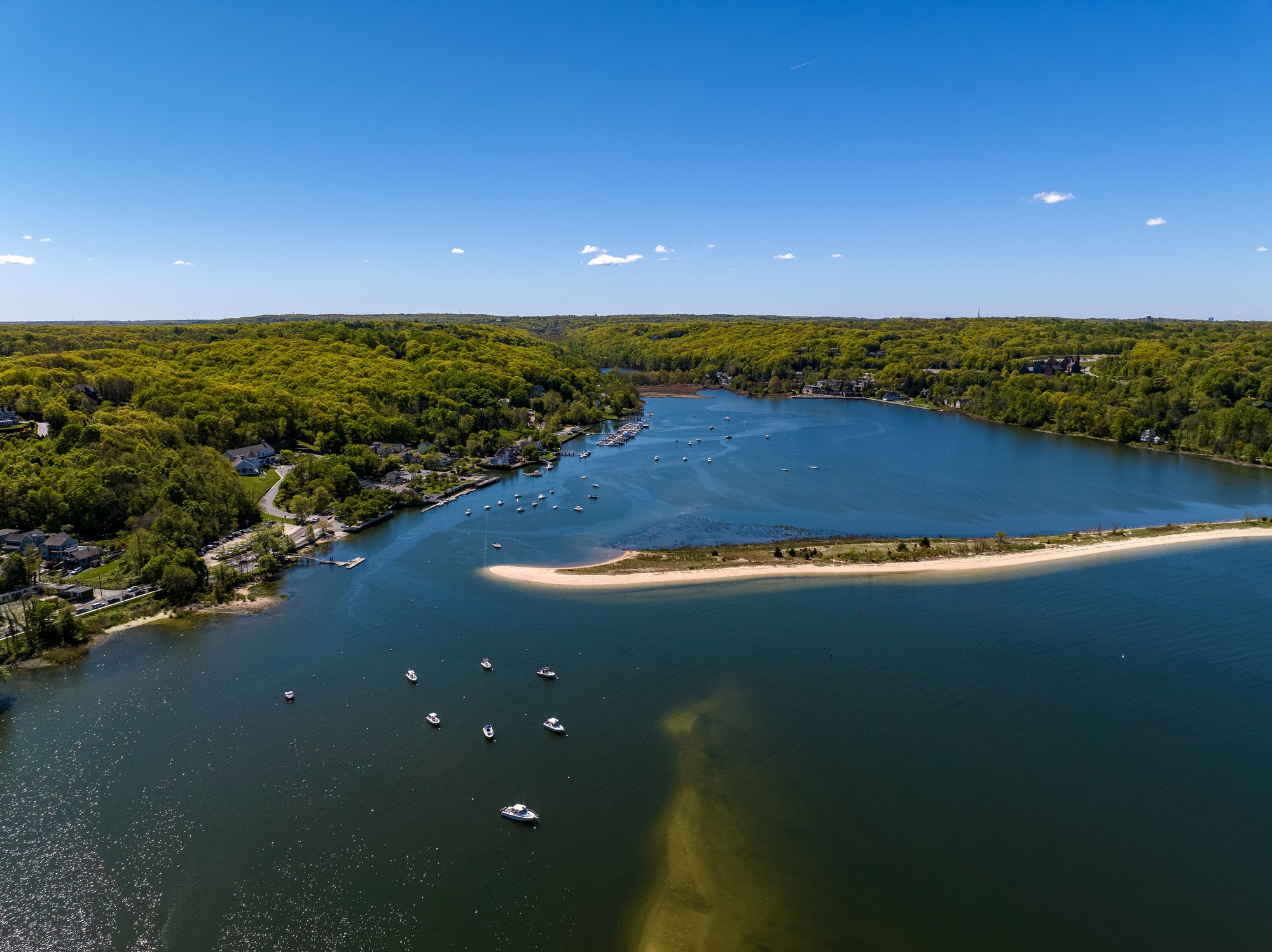 An aerial view over a large sandbar in the green waters of Oyster Bay in Lloyd Harbor on Long Island, NY on a sunny day