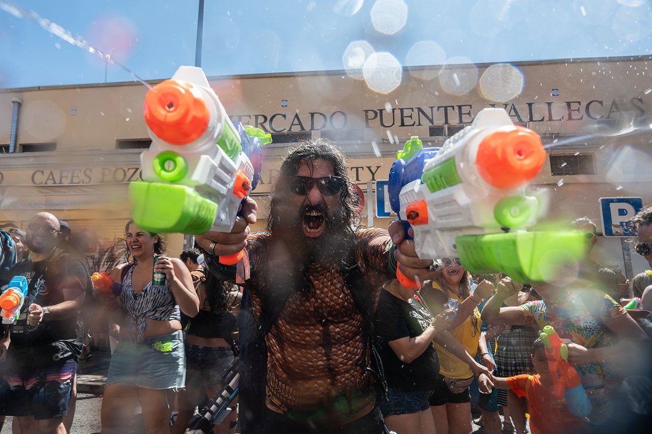 Revelers don water guns at the annual summer water fight celebrated in the Vallecas neighborhood of Madrid. (Marcos del Mazo/LightRocket via Getty Images)