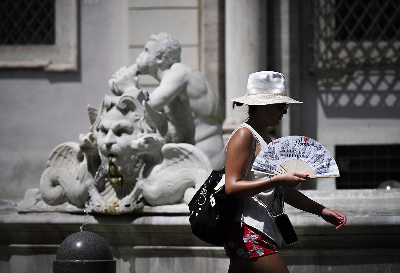 A woman with a fan walks in Piazza Navona in Rome on July 17, 2023, during a heatwave in Italy. Unforgiving heat scorched parts of the Northern Hemisphere on July 17, triggering health warnings and fanning wildfires in the latest stark reminder of the effects of global warming. (Tiziana Fabi/AFP via Getty Images)