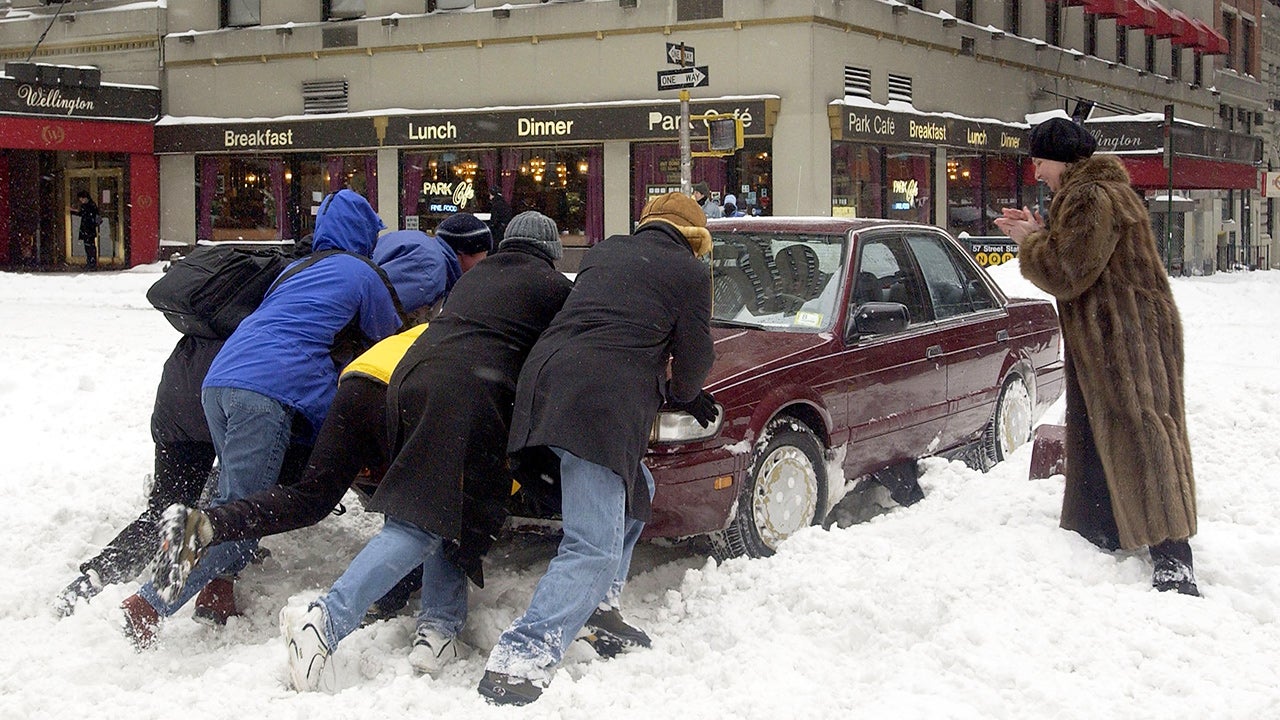 People helped push a car stuck on Seventh Avenue during a snowstorm on February 17, 2003, in New York City. (Ezra Shaw/Getty Images)