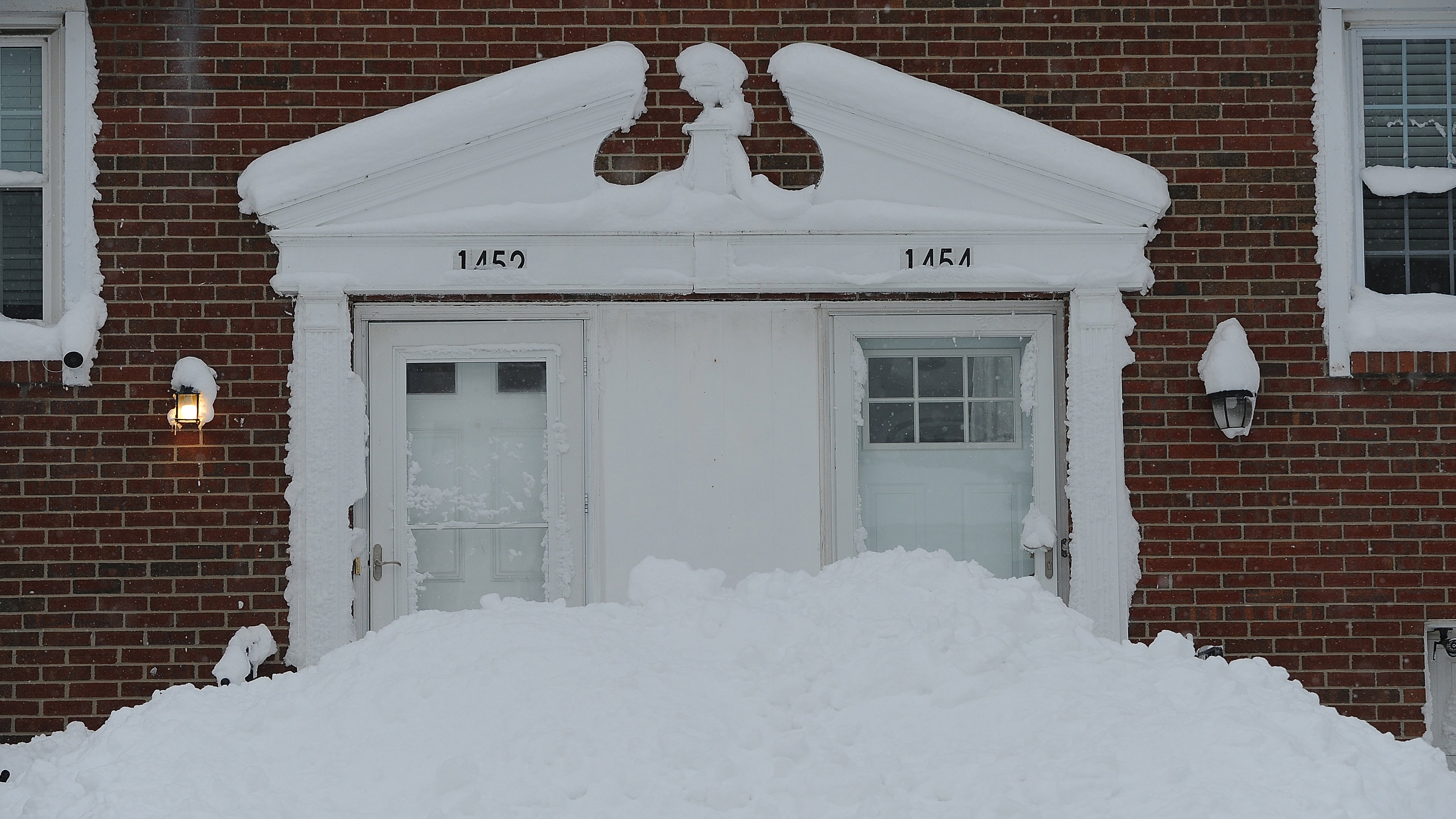 Snow piles up around the entrance doors of homes after over two feet of heavy lake effect snow on Dec.1, 2024, in Derby, New York. (John Normile/Getty Images)