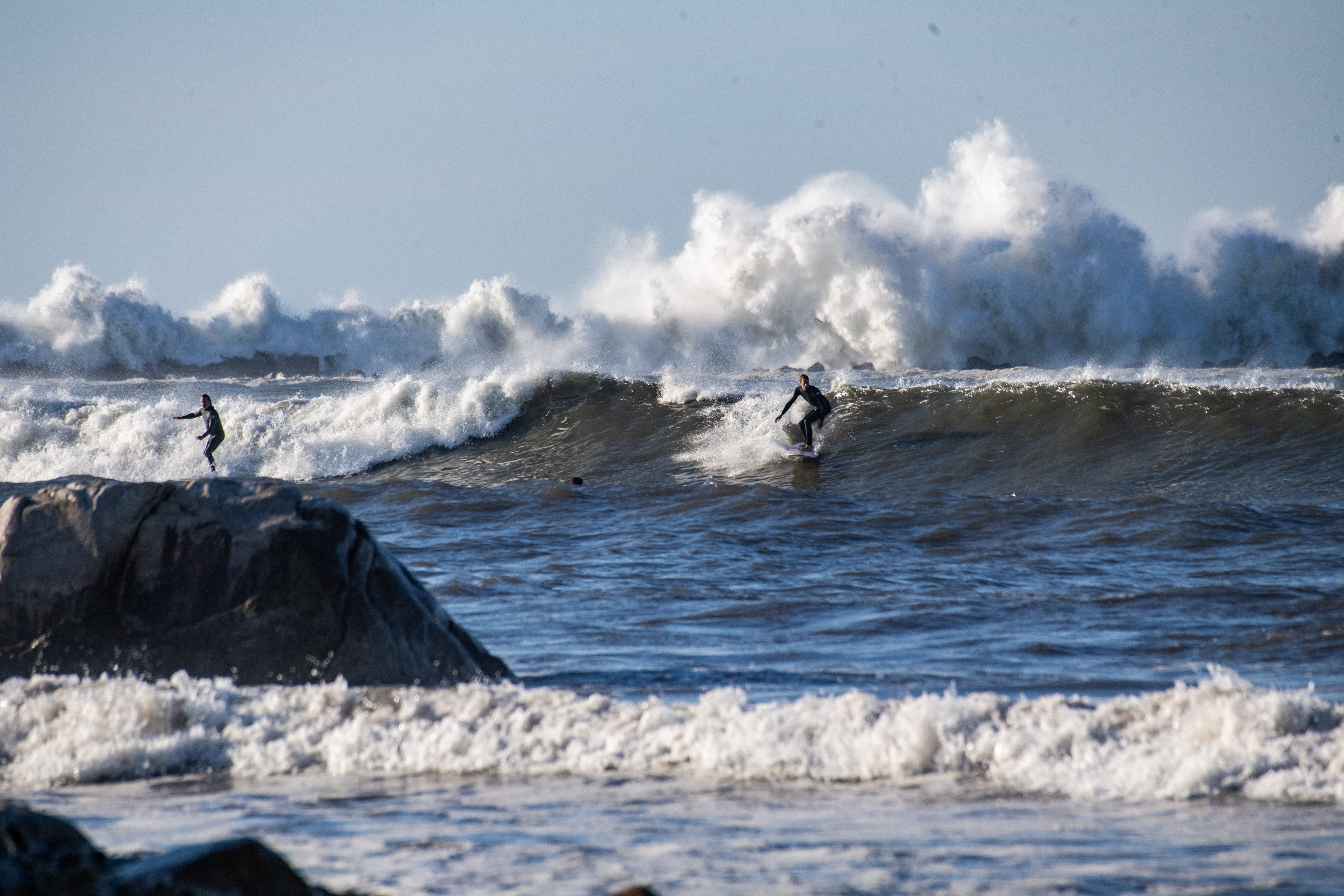 RHODE ISLAND, UNITED STATES - AUGUST 22: Surfers catch the extremely large waves caused by the hurricane in Narragansett, Rhode Island, United States on August 22, 2025. Large waves and rip currents gripped the East Coast as Hurricane Erin made its way offshore hundreds of miles away. (Photo by Joseph Prezioso/Anadolu via Getty Images)