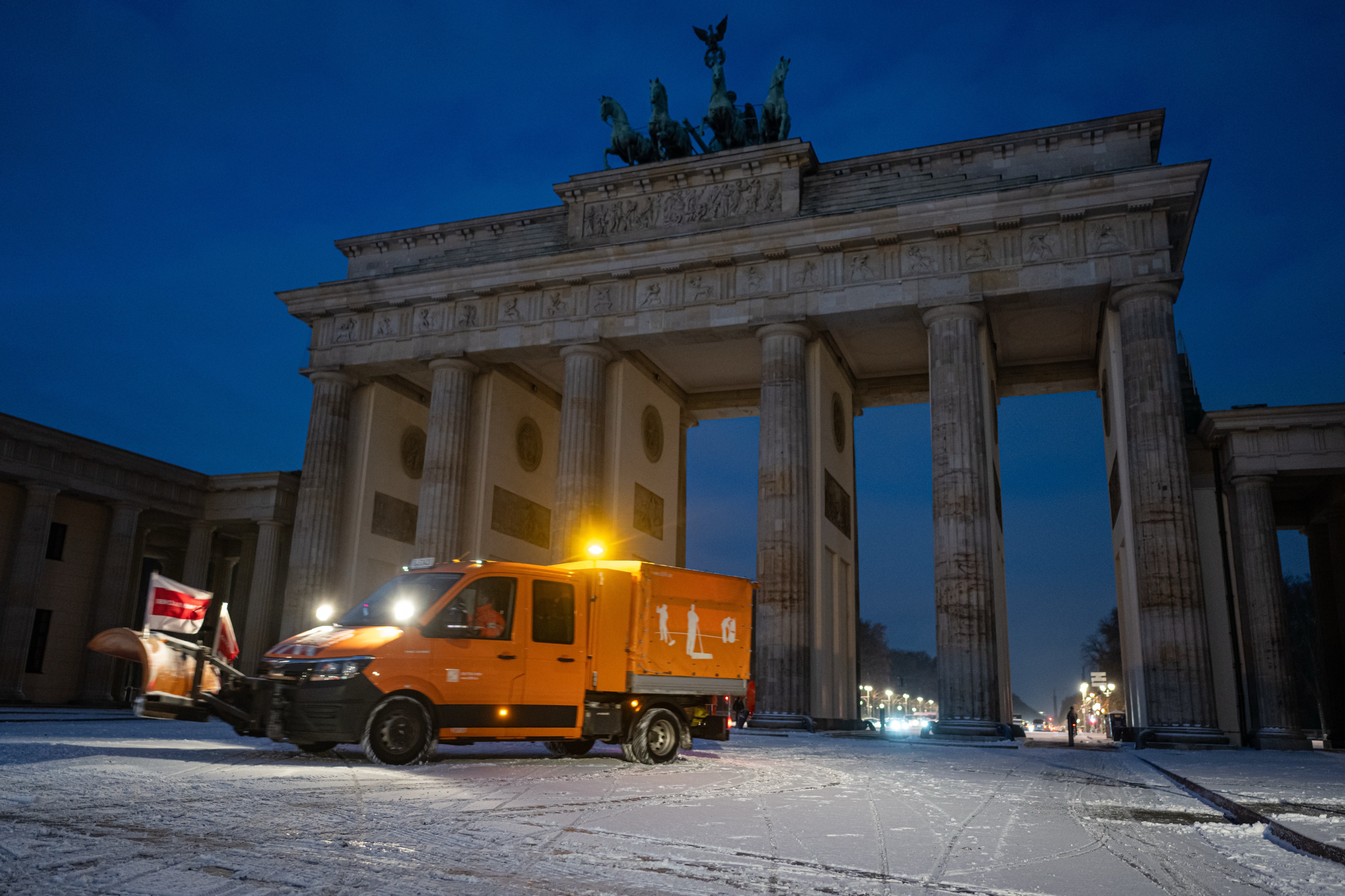 dpatop - 24 November 2025, Berlin: A snow clearing vehicle drives in front of the Brandenburg Gate after snowfall. Photo: Fabian Sommer/dpa (Photo by Fabian Sommer/picture alliance via Getty Images)