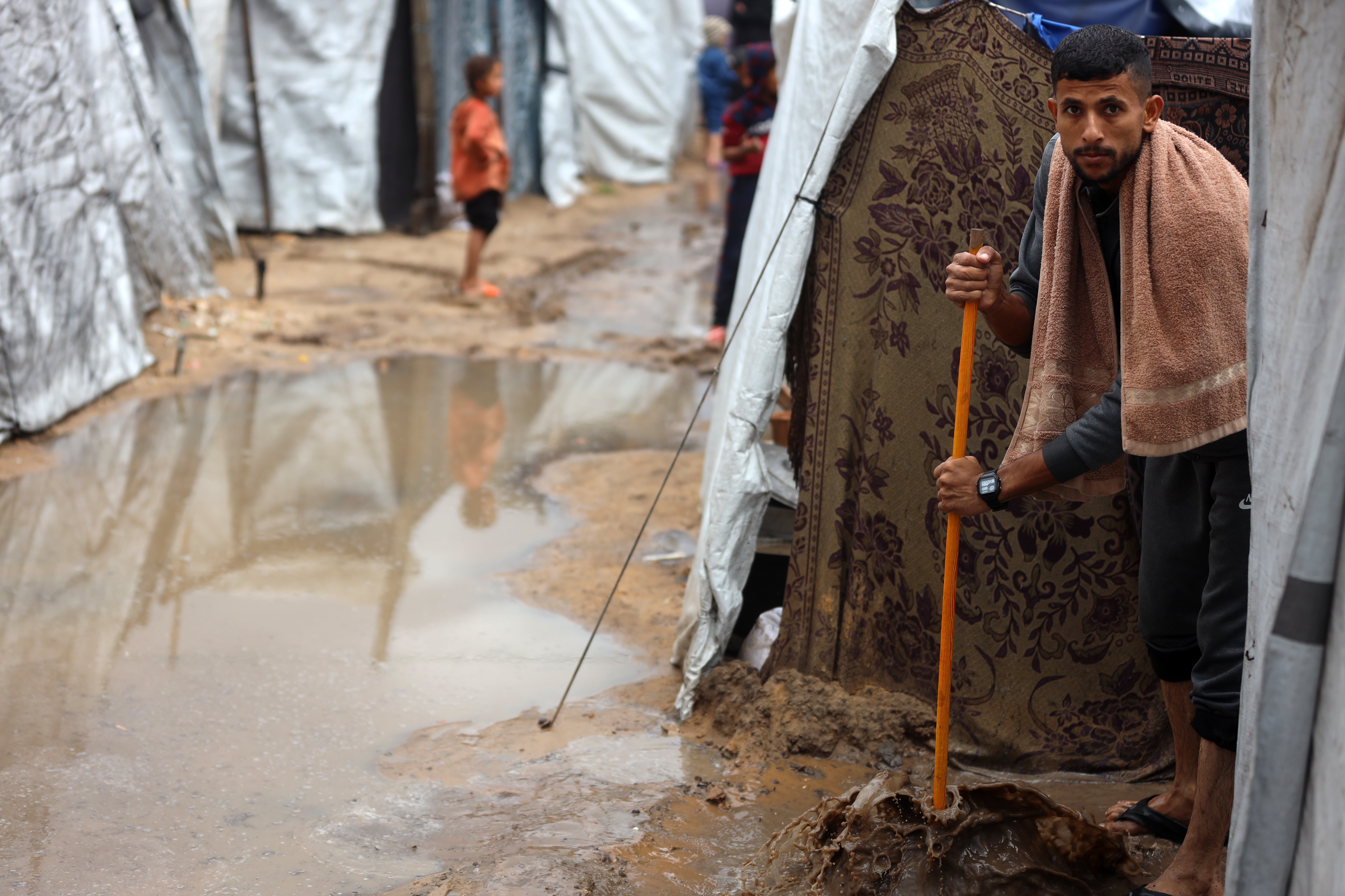 Palestinian men create channels in the sand to direct the rain at a makeshift camp housing displaced Palestinians in Gaza City, Palestine, on November 25, 2025. (Photo by Majdi Fathi/NurPhoto via Getty Images)
