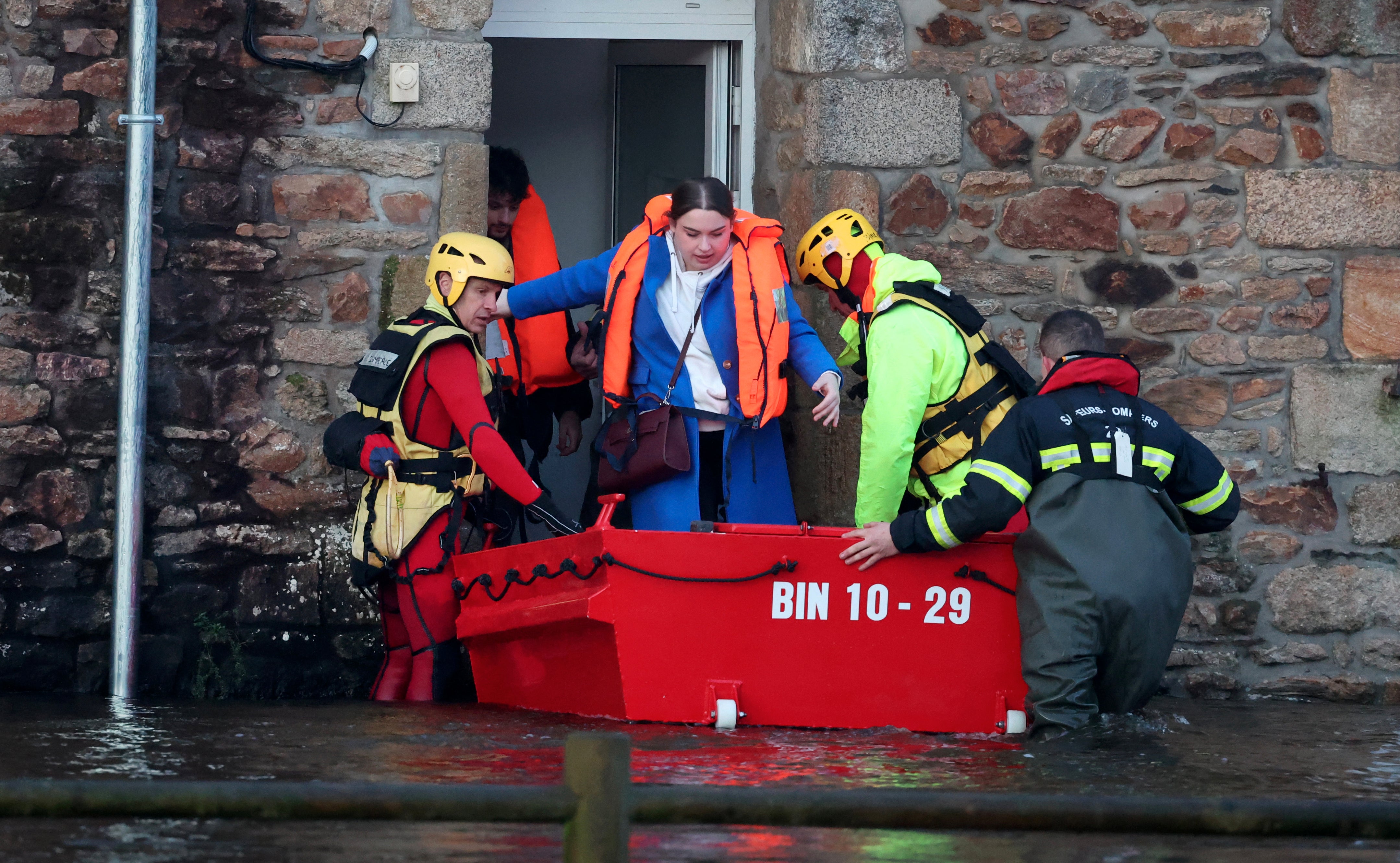 People are evacuated from their home during flooding caused by the overflowing of the Laita River in Quimperle, western France, on January 22, 2026. (Photo by Fred TANNEAU / AFP via Getty Images)