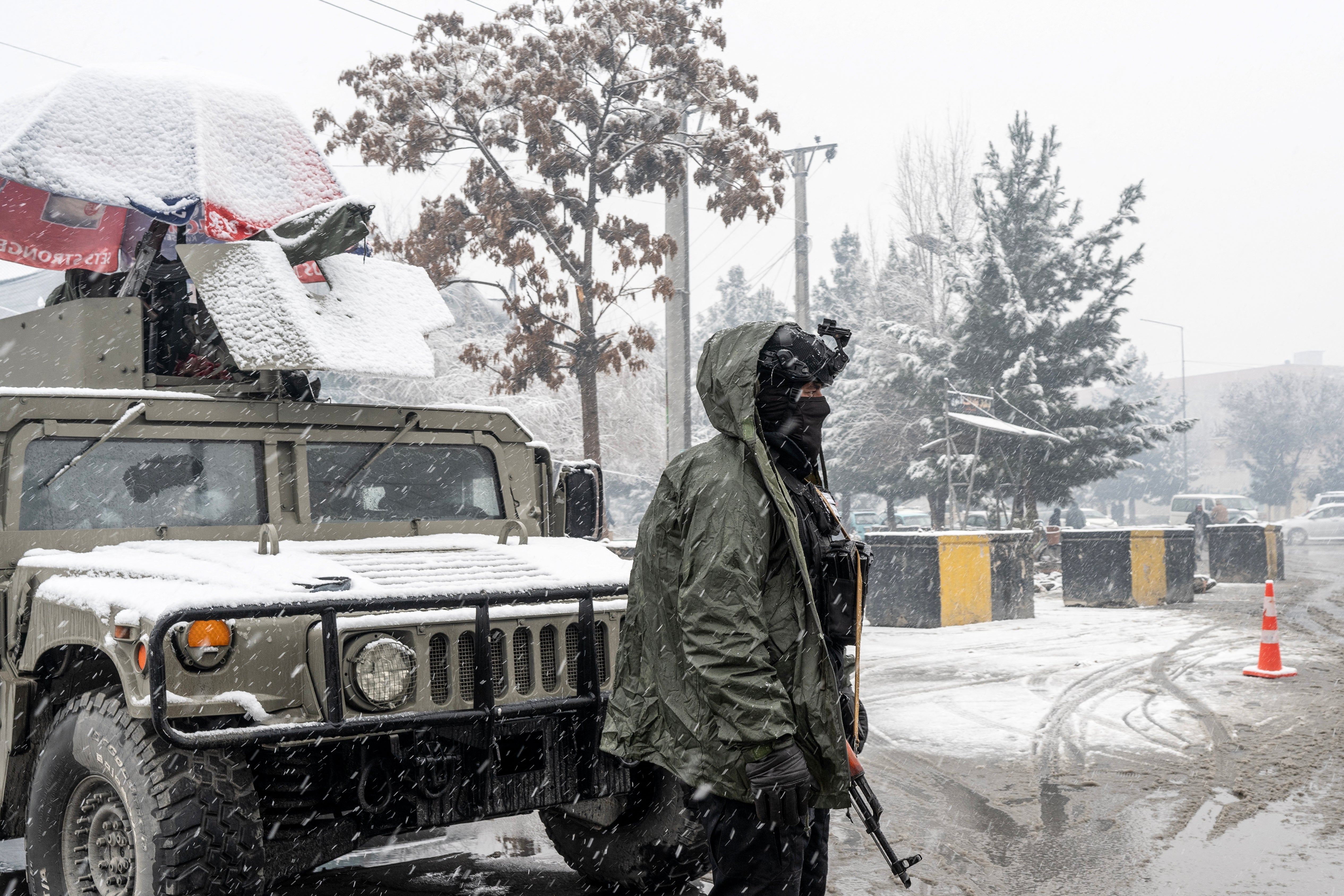 A Taliban security personnel stands guard at a checkpoint during snowfall in Kabul on January 22, 2026. Severe storms and a rain-triggered landslide have killed at least nine children across southern and eastern Afghanistan, officials said, with residents facing further risks as heavy snow hits the country. (Photo by Wakil KOHSAR / AFP via Getty Images)