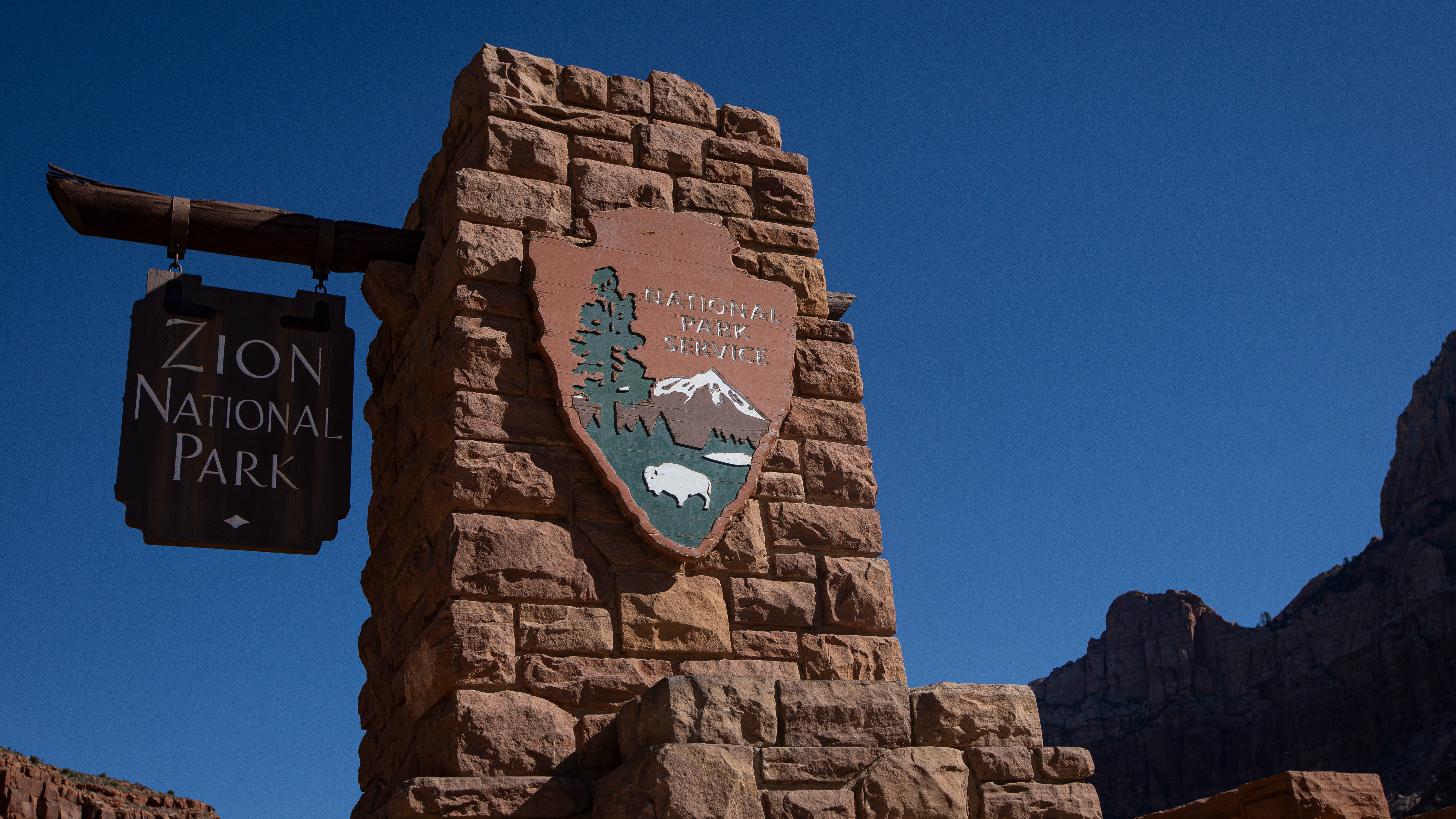 A detail view of the National Park Service and Zion National Park signs outside the entrance of the park in Springdale, Utah, on March 7, 2026. (Photo by Michael Yanow/NurPhoto via Getty Images)