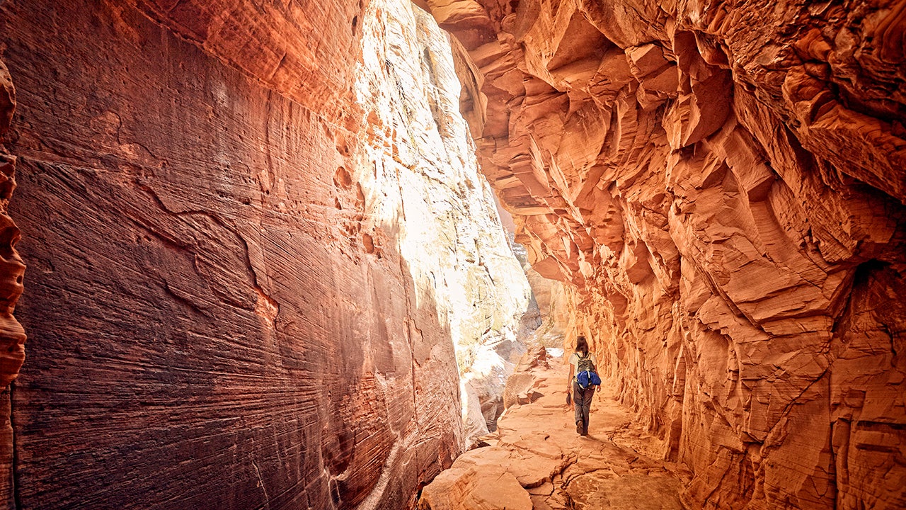 A hiker walks through the Zion National Park Narrows in Utah. (James O'Neil via Getty Images)