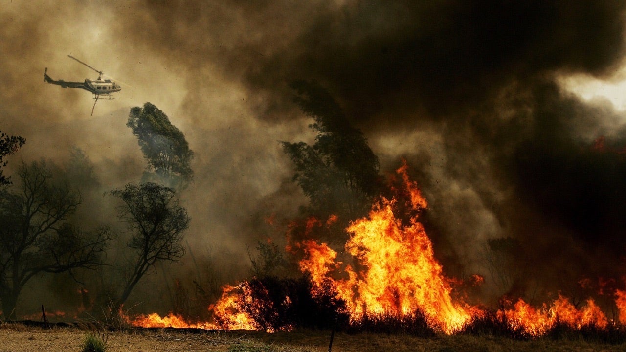 ESCONDIDO, CA - OCTOBER 23:  A helicopter prepares to drop water on a brushfire October 23, 2007 in the Del Dios area of Escondido, California.  The Witch Fire, which started outside of Ramona, California has burned over a thousand structures and forced over 300,00 to evacuate in what is being called San Diego's worst fire ever. (Photo by Sandy Huffaker/Getty Images)