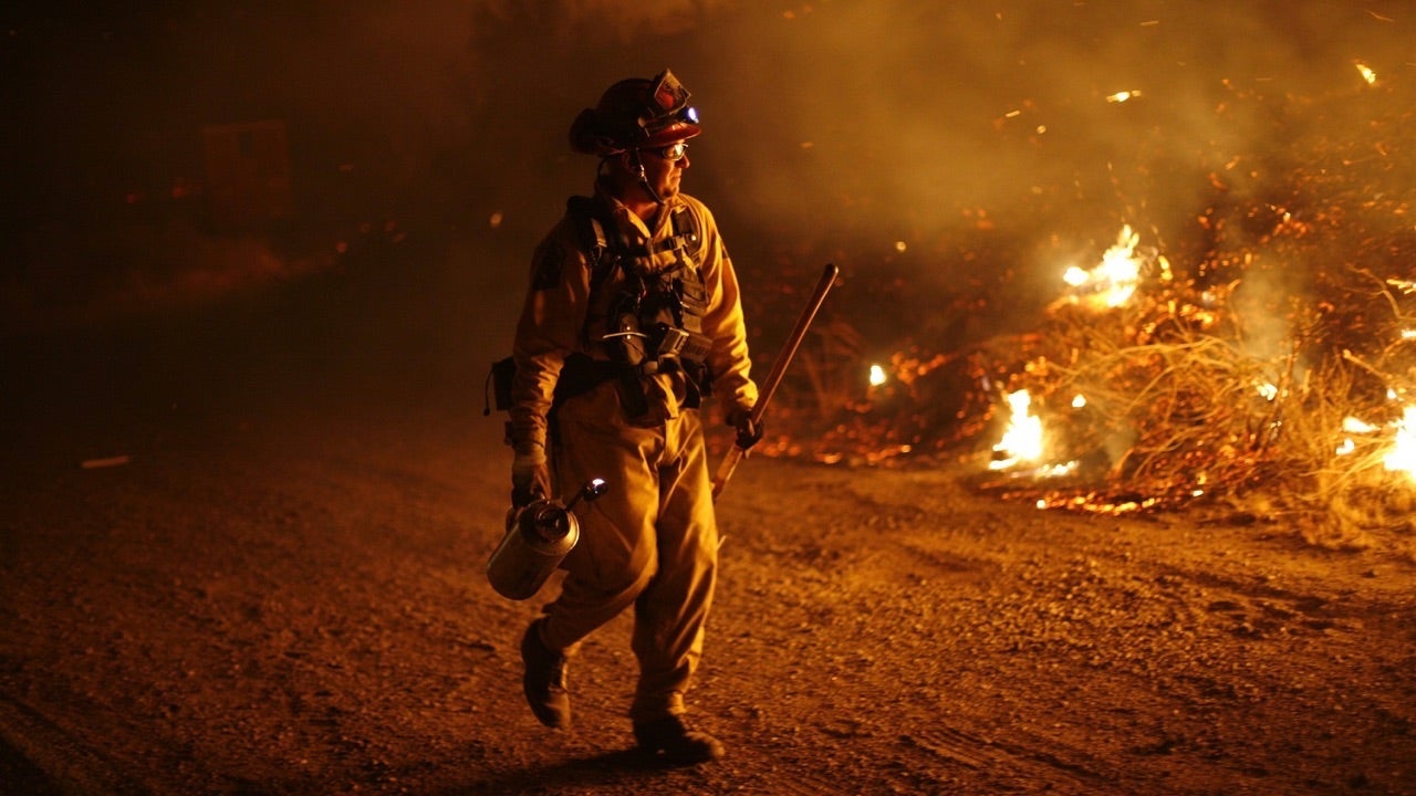 LA JOLLA INDIAN RESERVATION, CA OCTOBER 25:  a Firefighter battles the Poomacha fire in the early morning October 25, 2007 on the La Jolla Indian Reservation, California. Over 700 firefighters are fighting the 35,000-acre Poomacha fire, which is threatening to merge the nearby 200,000-acre Witch fire.  (Photo by Eric Thayer/Getty Images)