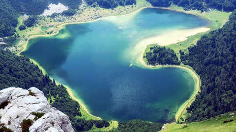 View of the Trnovacko Lake lake in northern Montenegro, best known for its heart-like shape. The area is popular with local summer campers. (Maya Karkalicheva/Moment via Getty Images)