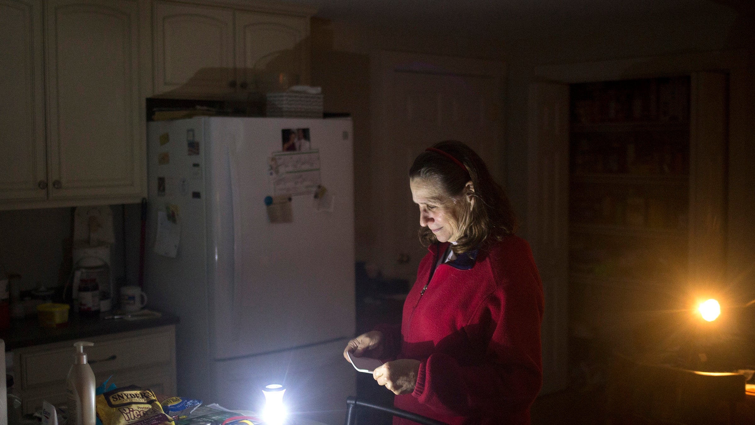 CUMBERLAND, ME - 2 DE NOVIEMBRE: Brenda Sherwin está en su cocina al anochecer, iluminada por linternas que funcionan con baterías. Ella y su marido no han tenido electricidad desde la madrugada del lunes. Sin embargo, cuatro días no es el tiempo más largo que han estado sin poder. La pareja se quedó sin electricidad durante 10 días después de la tormenta de hielo de 1998. Sherwin, que dirige una guardería en su casa, dijo: "Lo peor es no tomar café." (Foto del personal por Brianna Soukup/Portland Portland Press Herald vía Getty Images)