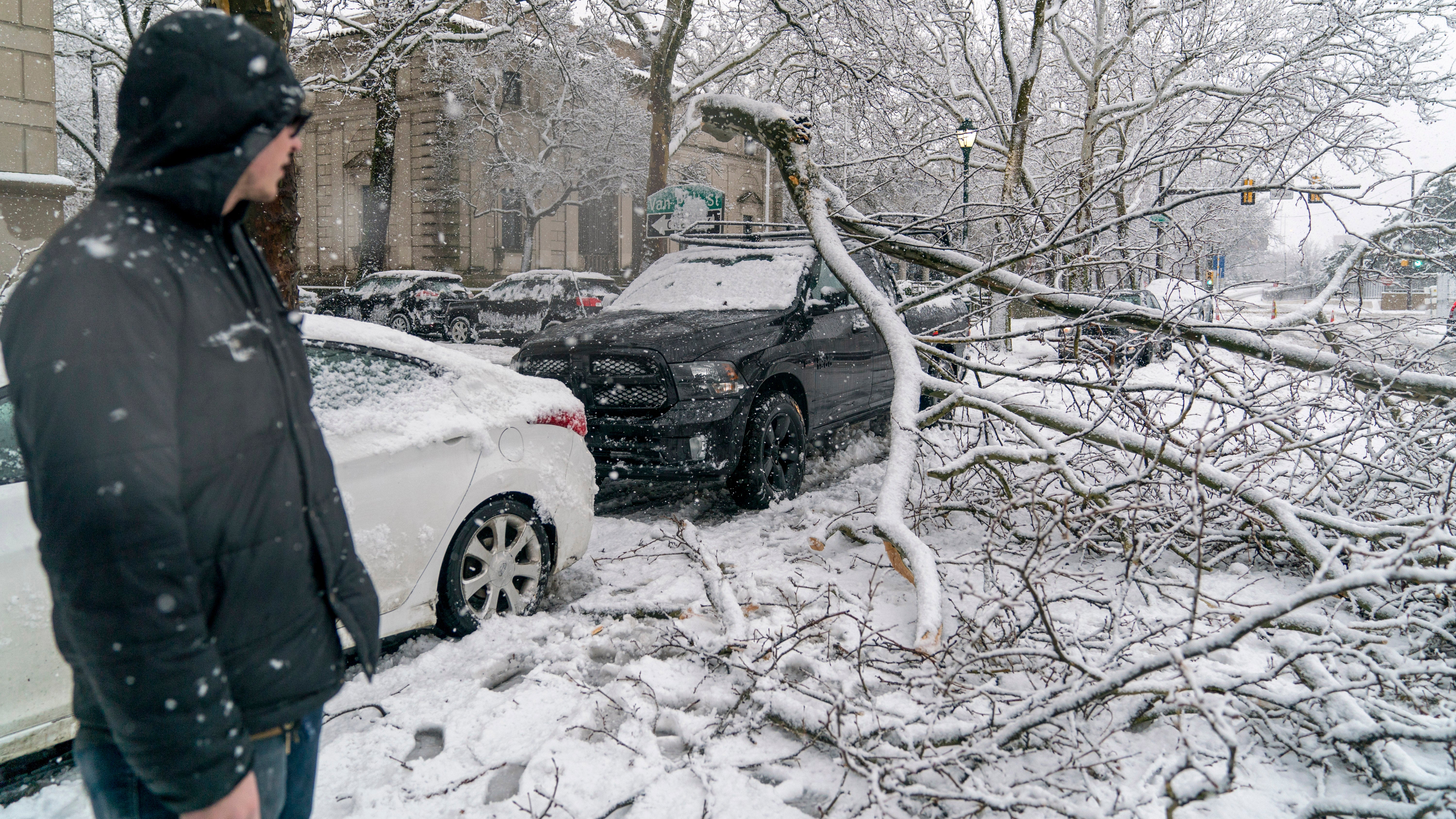 A man looks at a branch that fell from heavy snow and landed on his friend's truck on March 7, 2018 in downtown Philadelphia, Pa. Winter Storm Quinn is the second nor'easter to hit the Northeast within a week and is expected to bring heavy snowfall and winds, raising fears of another round of electrical outages.  (Jessica Kourkounis/Getty Images)                                  
