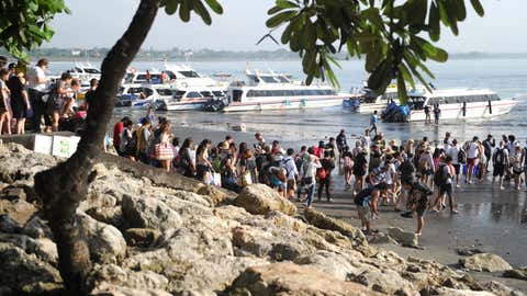 Wisatawan bersiap menaiki perahu ke pulau Nusa Penida dari pantai Sanur di Bali pada 21 Maret 2018. / AFP PHOTO / SONNY TUMBELAKA (Kredit foto harus dibaca SONNY TUMBELAKA/AFP via Getty Images)
